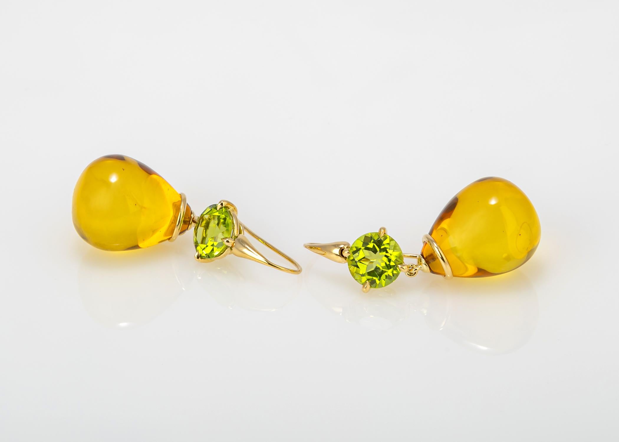 This one of a kind handmade pair of earrings is neutral and wearable for day and evening. Brilliant cut peridot's are paired with amber. 1 7/8's in length.