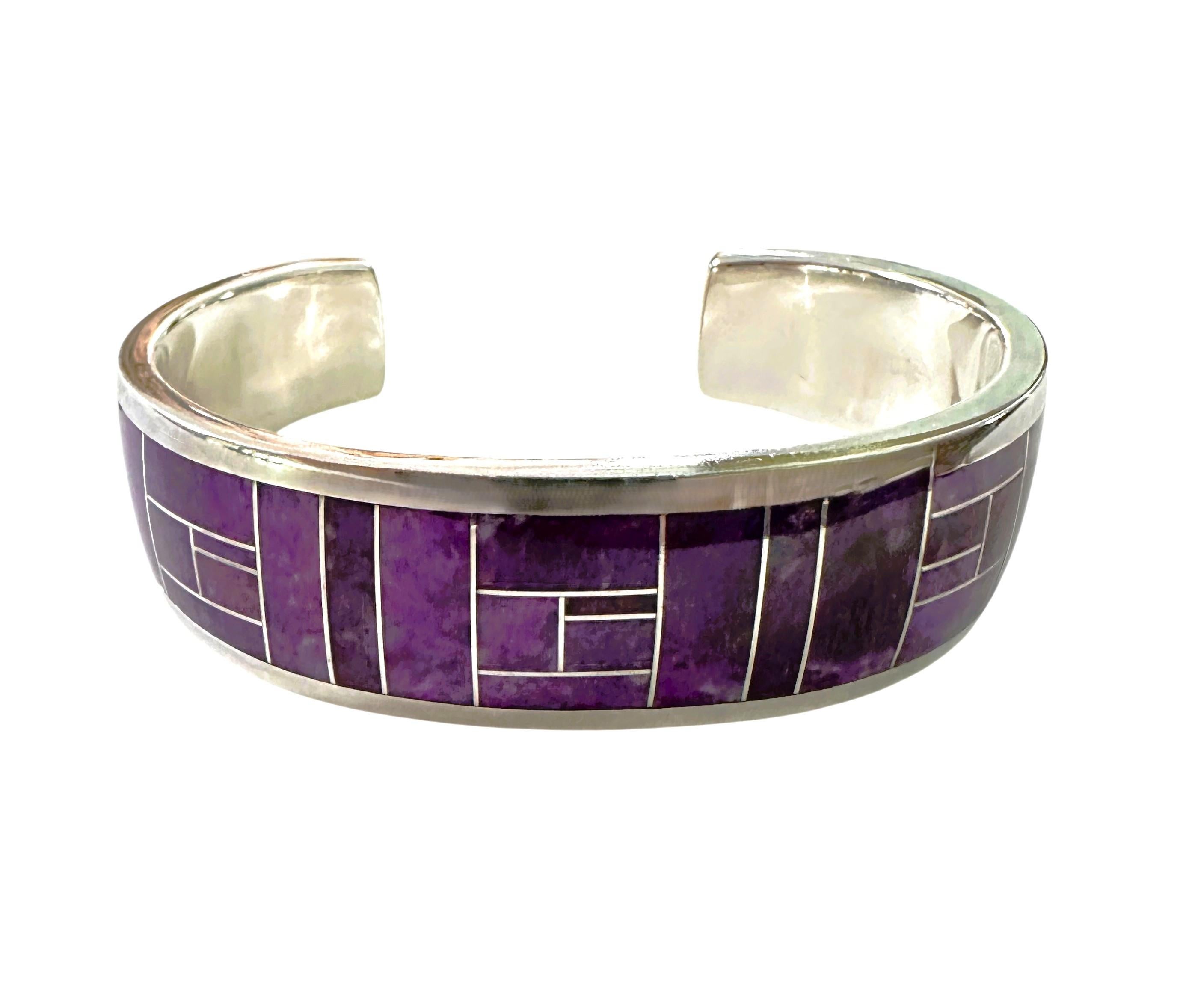 This is a very striking hand-crafted Cuff Bracelet.  It is Inlaid Purple Sugilite stone.  It can be worn by men and women.  It was made by popular Navajo Artist David Rosales and has his stamp on it. The bracelet is thick silver and it is 6.5 inches
