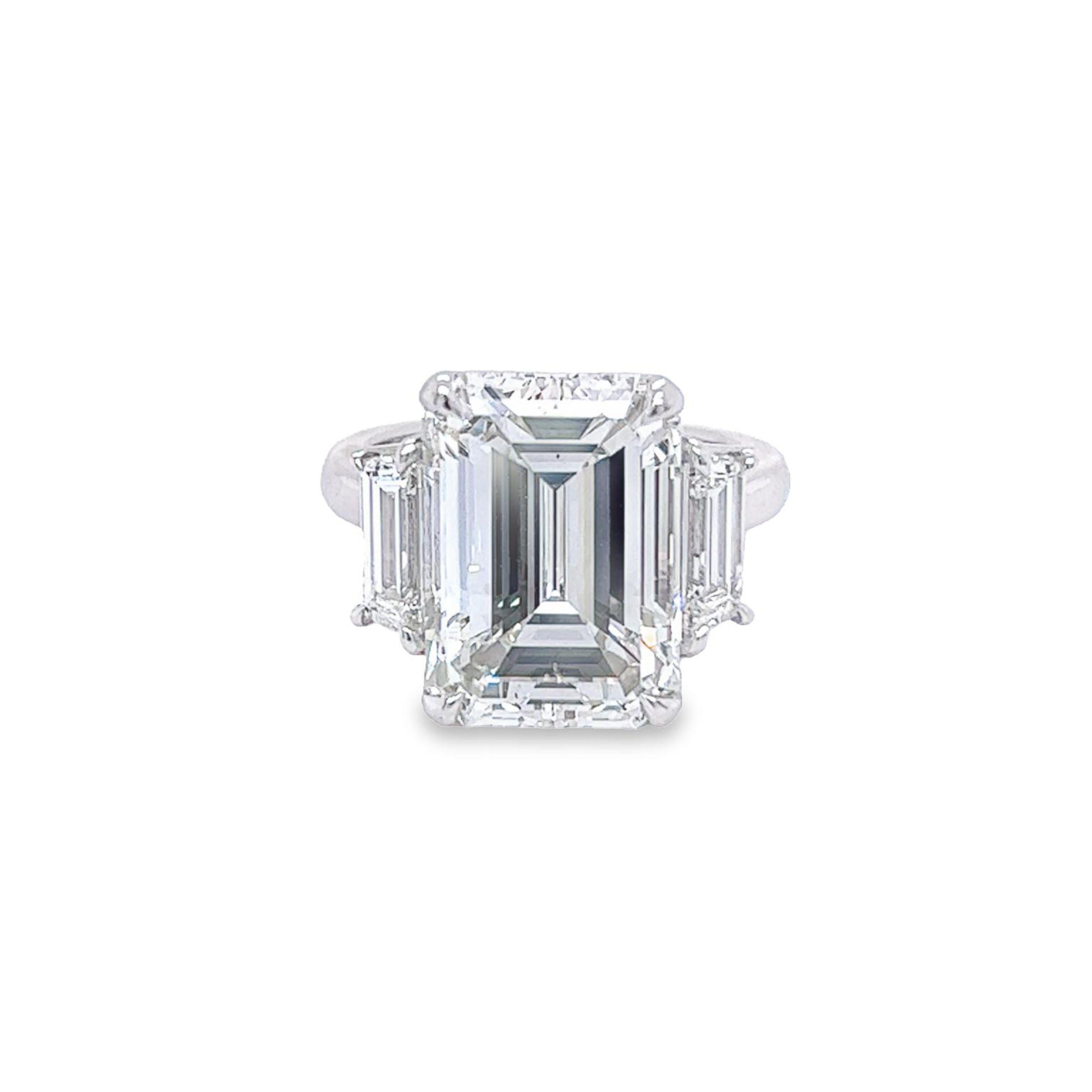 Rosenberg Diamonds & Co. 10.07 carat Emerald cut J color SI1 clarity is accompanied by a GIA certificate. This exceptional SI1 is set in a handmade platinum setting with perfectly matched pair of step cut side stones flanking on both sides with a