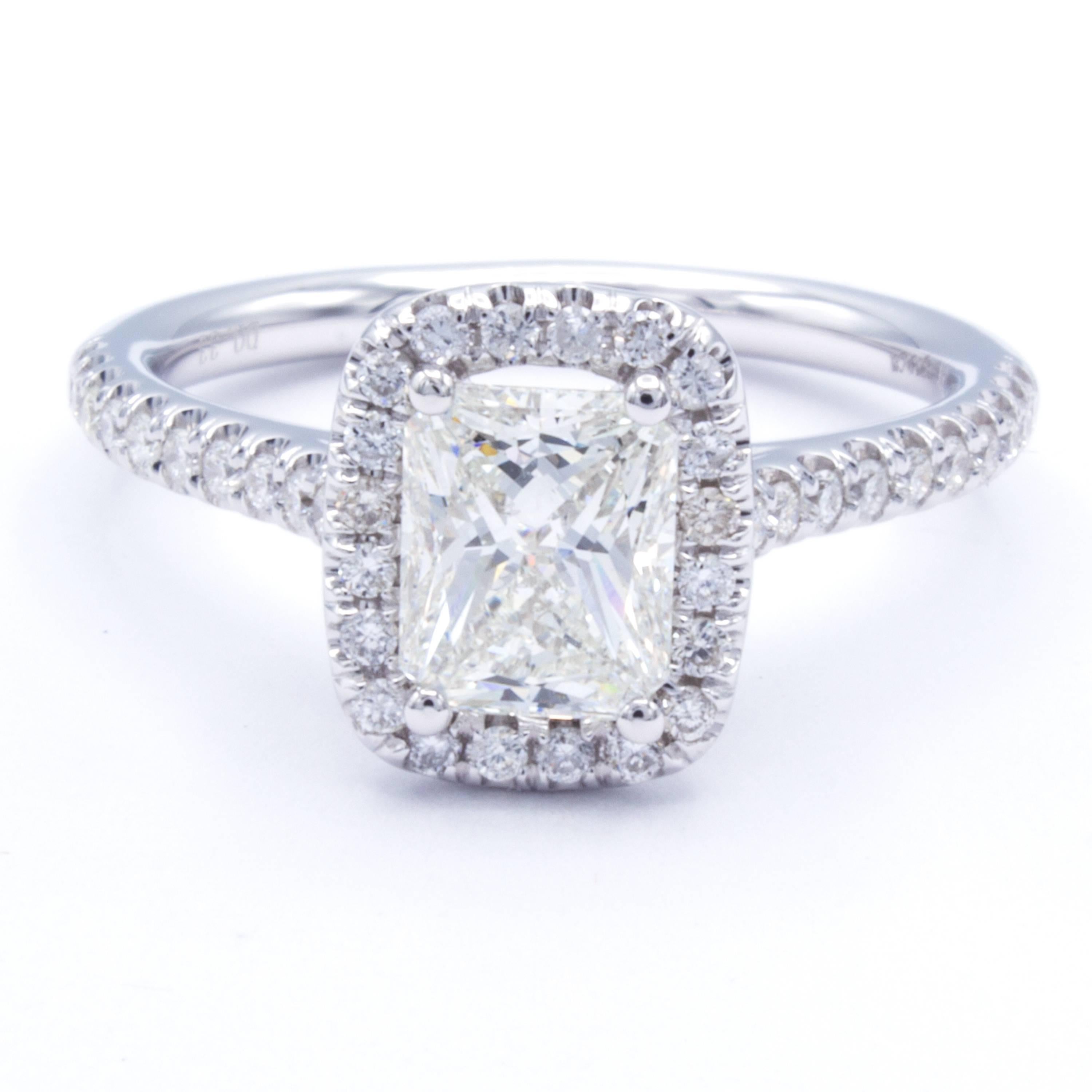 A delicate setting of 18Kt white gold carries a beautiful GIA certified 1.02 carat radiant cut diamond in this Rosenberg Diamonds & Co. diamond engagement ring. Glittering pave set round brilliant diamond accents travel around the center stone to