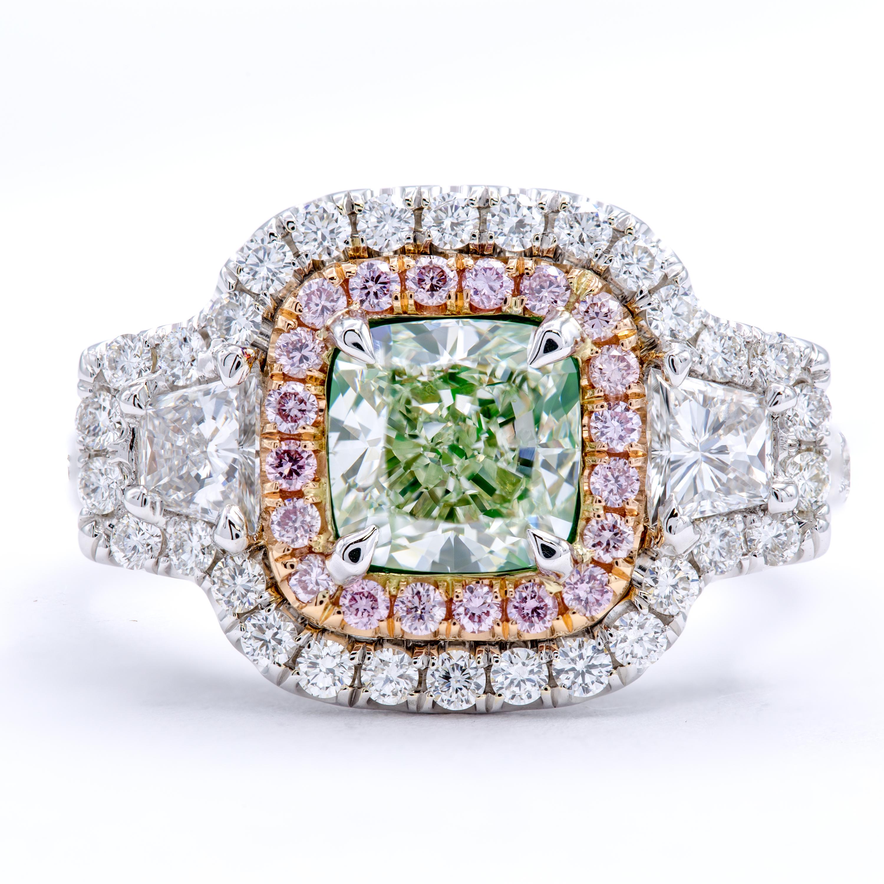 A GIA certified natural fancy light green diamond boasting an exceptionally rare color within a beautiful cushion cut shape. Two trapezoid side stones accent wonderfully on a band of 18Kt white and rose gold set with a double halo of natural fancy