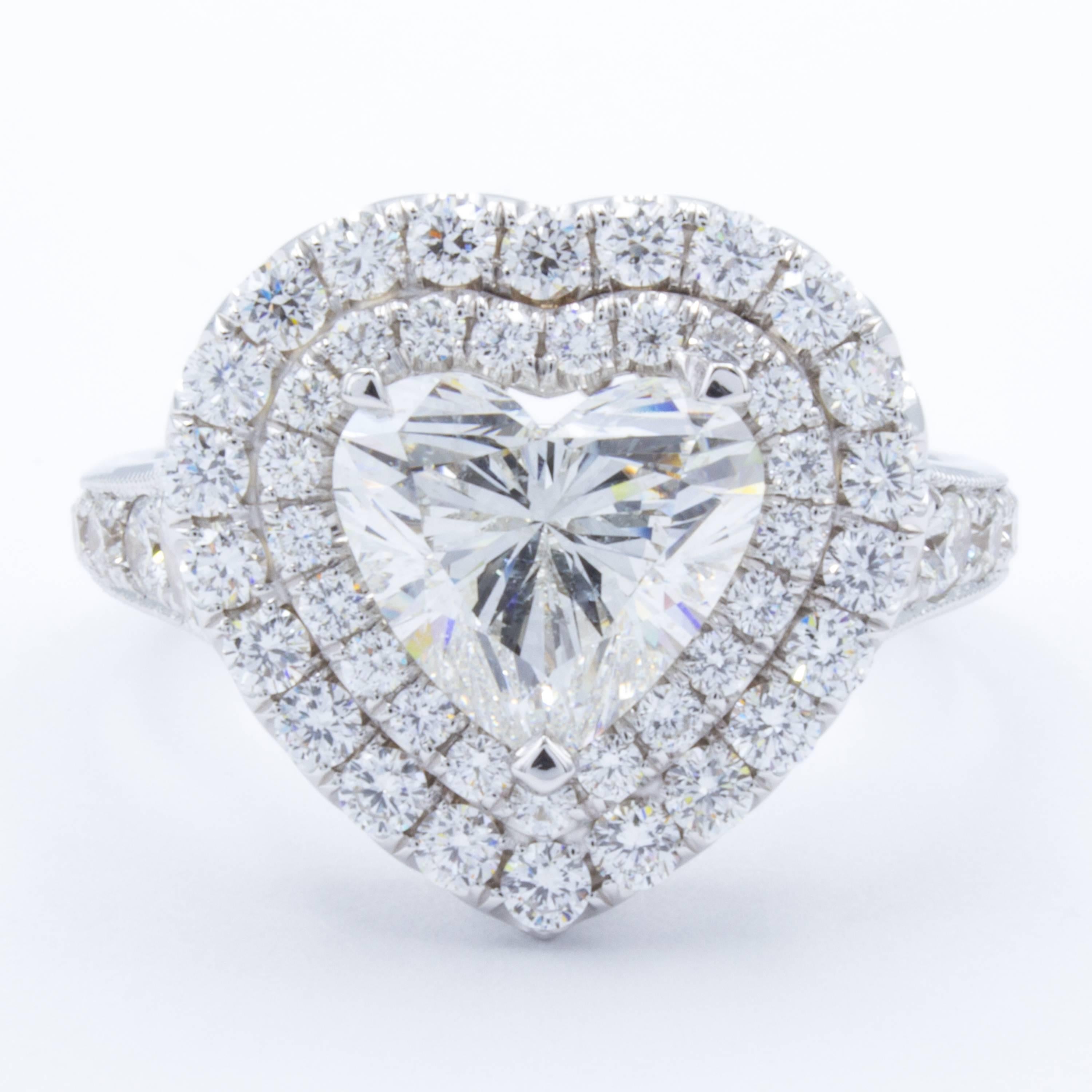 A romantic Rosenberg Diamonds & Co. diamond engagement ring displays a bouquet of shimmering pave set diamonds and a beautiful GIA certified 2.01 carat heart shaped diamond. Embraced in 18Kt white gold, each pave set diamond creates both an elegant
