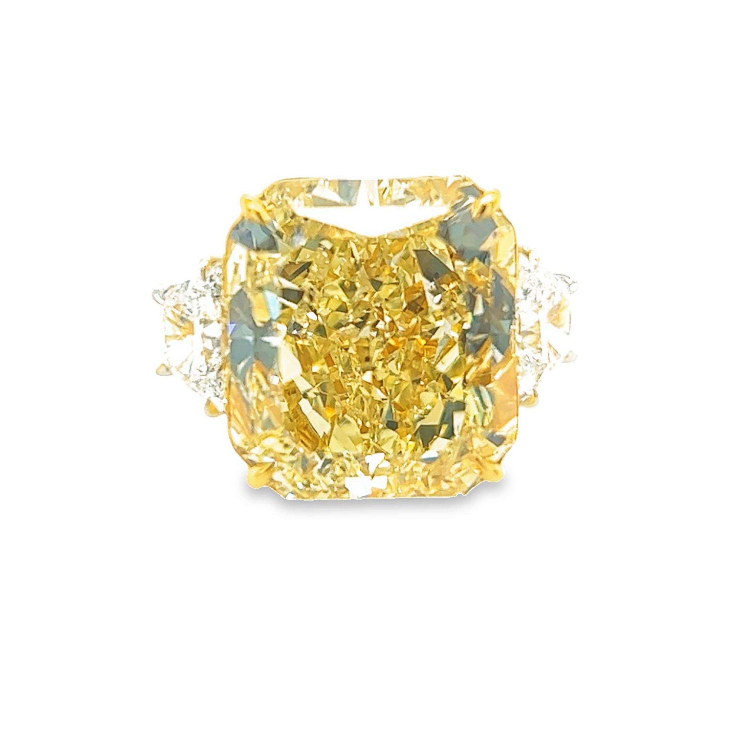 Rosenberg Diamonds & Co. 32.01 carat Radiant Cut Fancy Yellow SI2 clarity is accompanied by a GIA certificate. This astonishing radiant cut is set in a handmade platinum & 18k yellow gold setting with perfectly matched pair of trapezoid side stones