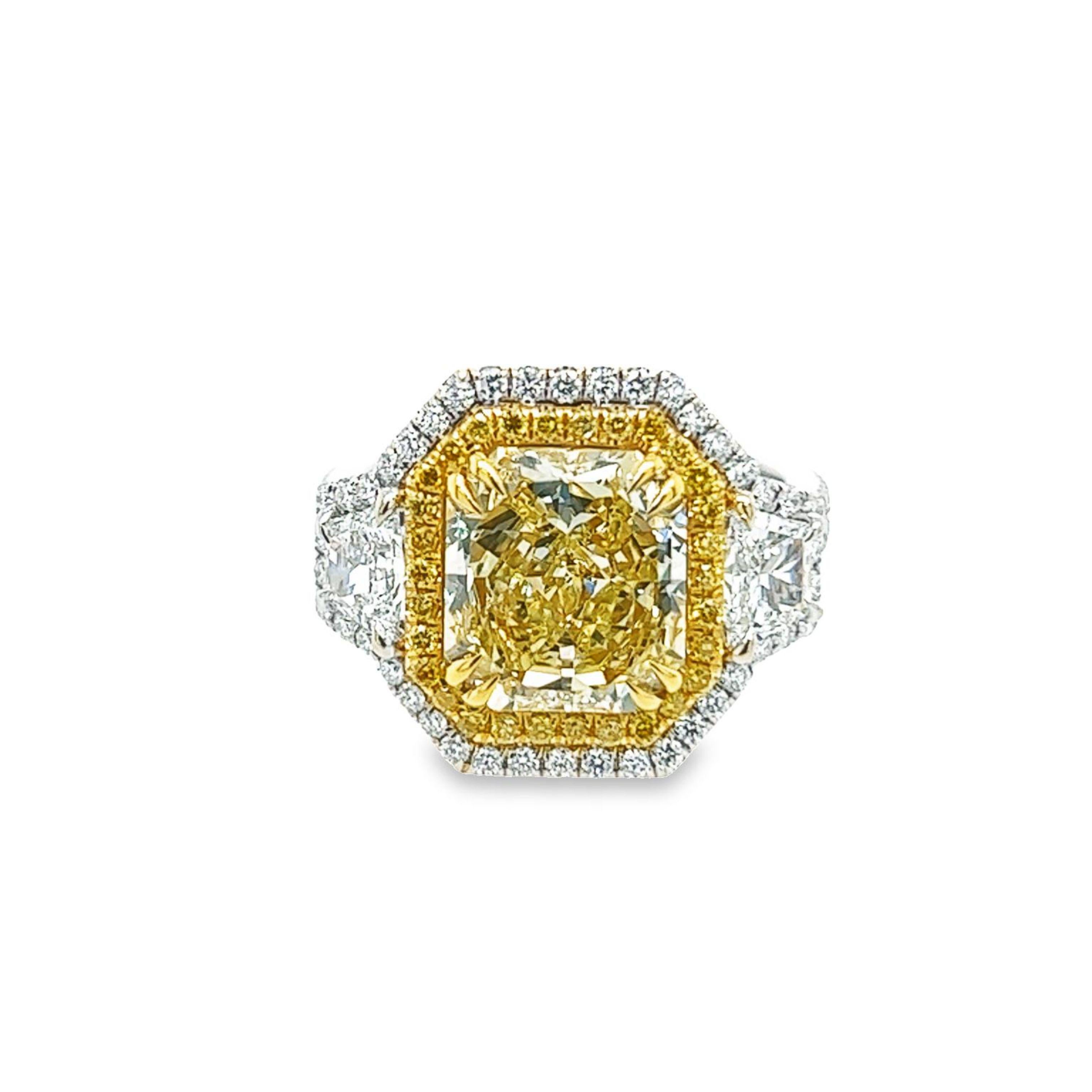 Rosenberg Diamonds & Co. 3.67 carat Radiant cut Fancy Yellow VVS2 clarity is accompanied by a GIA certificate. This beautiful bright Radiant cut is set in a 18k white & yellow gold setting with perfectly matched pair of trapezoid side stones