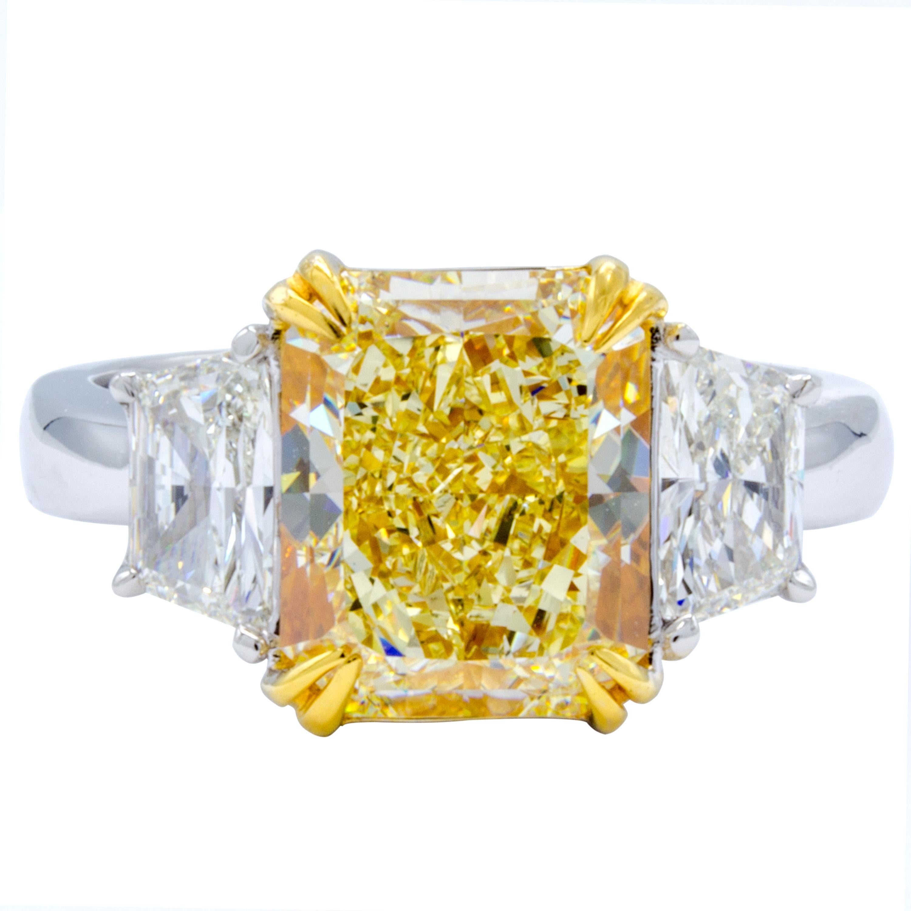 This glistening Rosenberg Diamonds & Co. diamond engagement ring sets a beautiful GIA certified radiant cut natural fancy light yellow diamond at front and center within a band of pure platinum and 18Kt yellow gold. The center stone features an