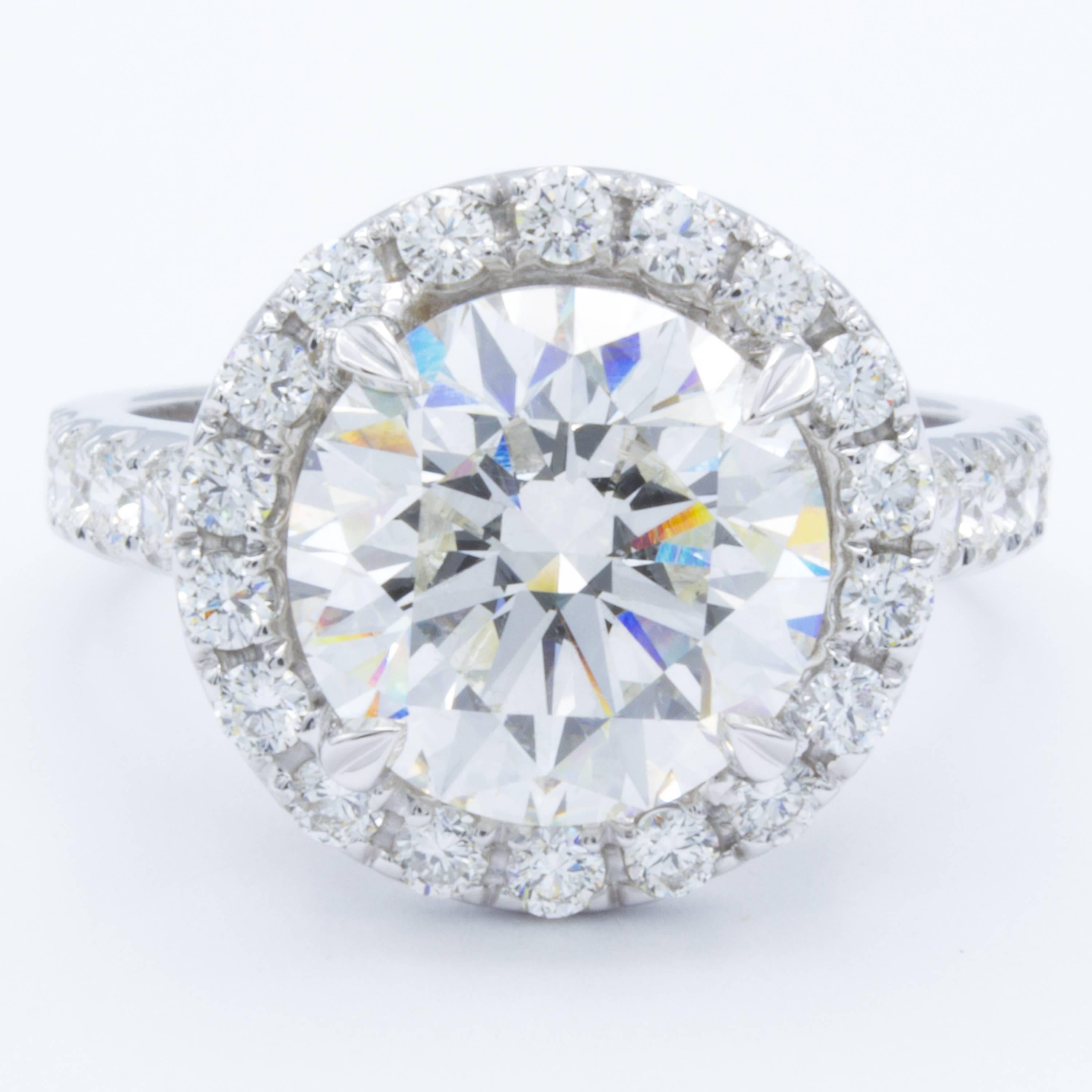 This gorgeous Rosenberg Diamonds & Co. engagement ring shows a GIA certified 4.00 carat round brilliant cut diamond unfurled within petals of glittering white pave set diamond accents on a band of 18Kt white gold. Designed by David Rosenberg.
 
