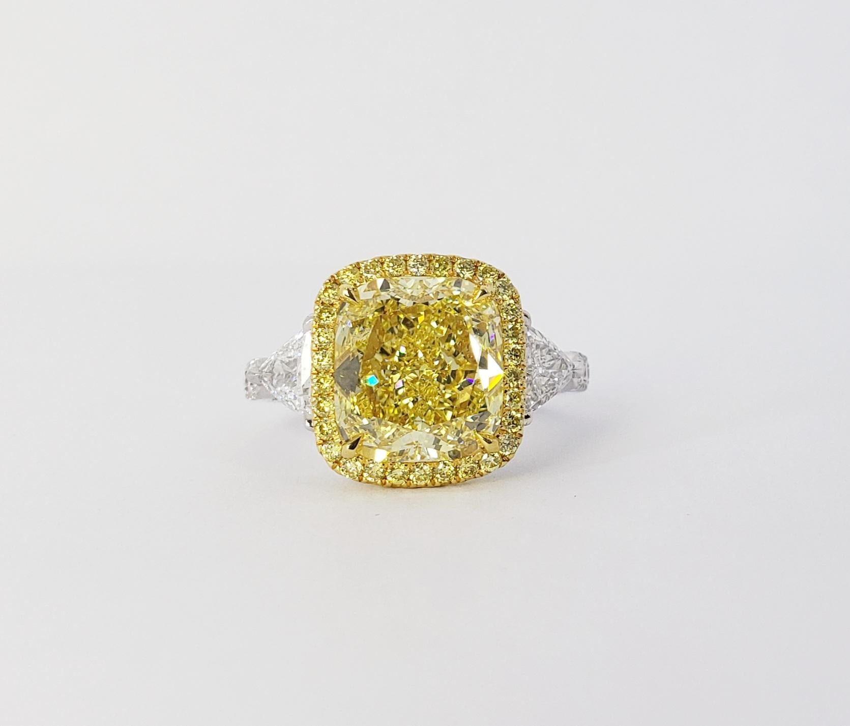 Rosenberg Diamonds & Co. 4.03 carat Cushion Cut Fancy Intense Yellow VVS2 clarity is accompanied by a GIA certificate. This beautiful bright cushion cut is set in a handmade 18k white gold setting with perfectly matched pair of trillion side stones