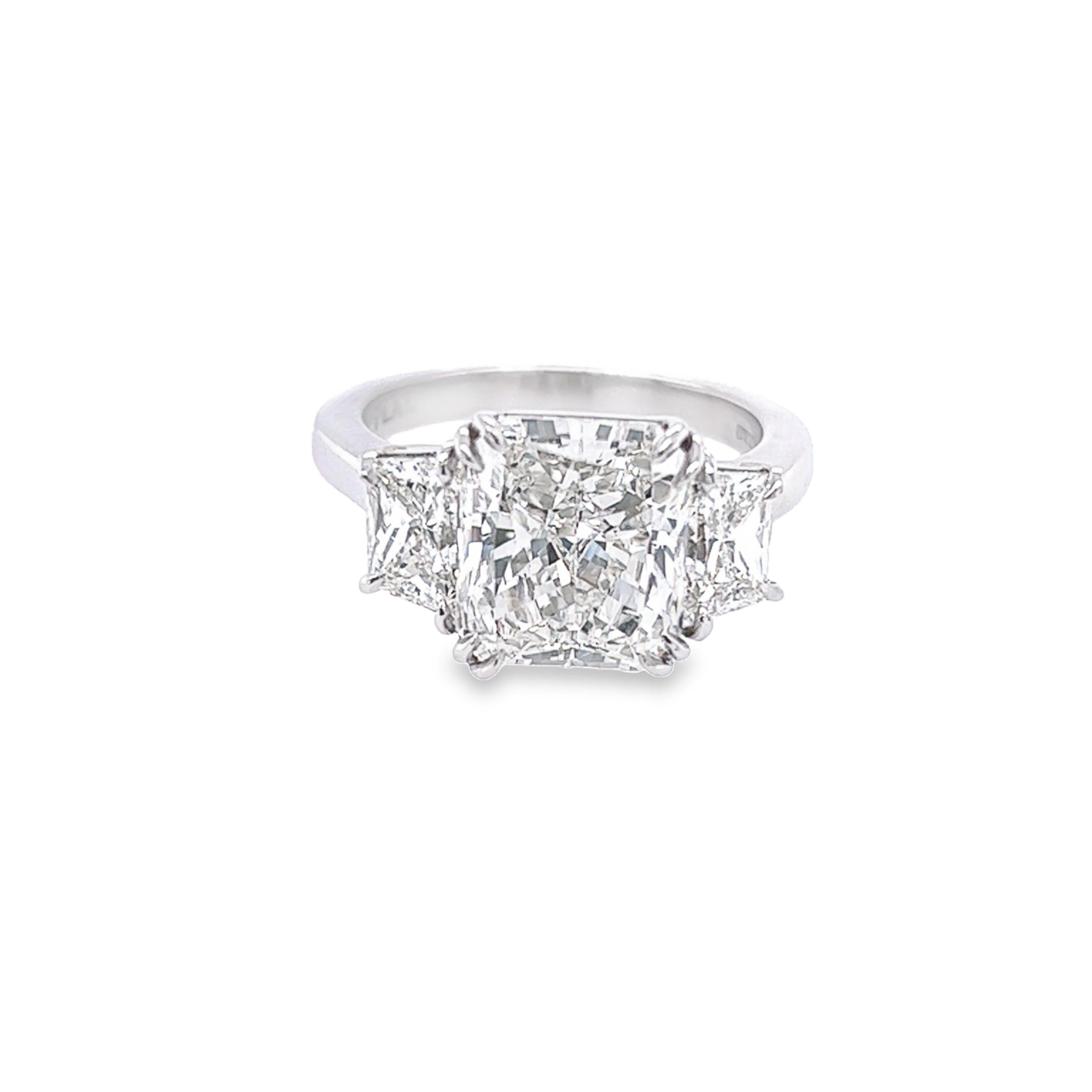 Rosenberg Diamonds 4.34 carat Radiant cut G color VS2 clarity is accompanied by a GIA certificate. This beautiful three-stone Radiant is full of brilliance and it is set in a handmade platinum setting with perfectly matched pair of trapezoid diamond