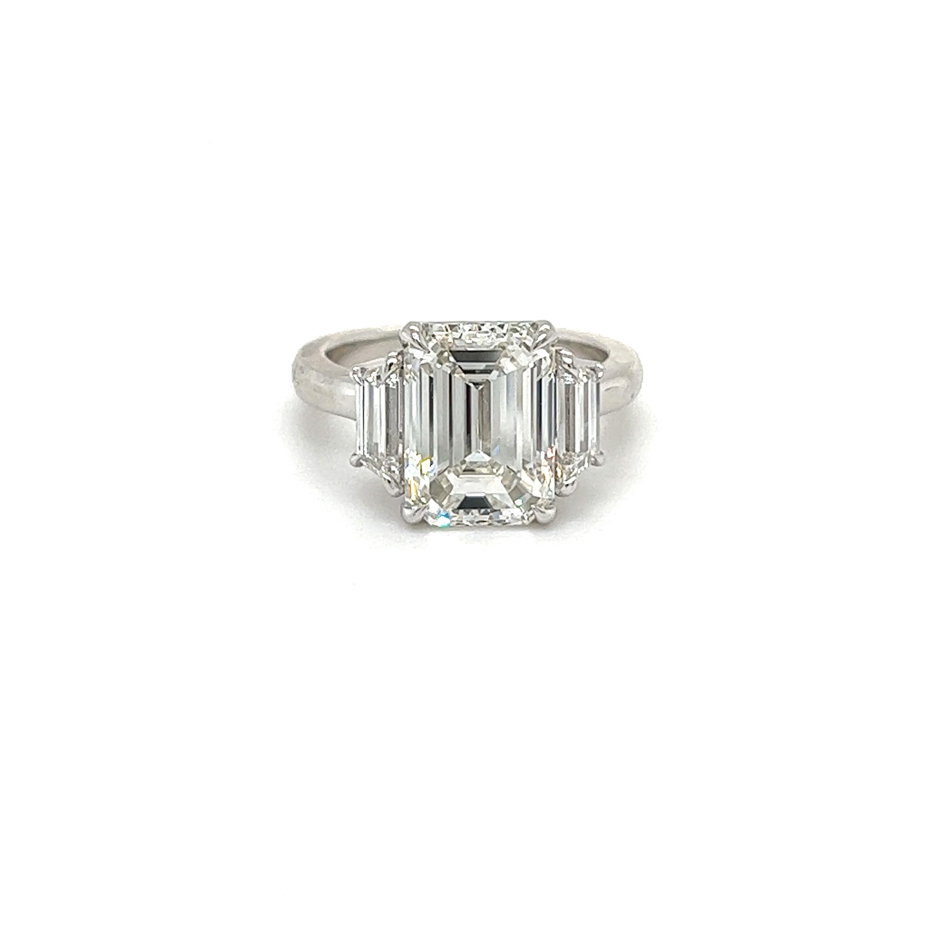 Rosenberg Diamonds & Co. 5.01 carat Emerald cut G color VS1 clarity is accompanied by a GIA certificate. This spectacular Emerald is set in a handmade platinum setting with perfectly matched pair of trapezoid side stones flanking on both sides with