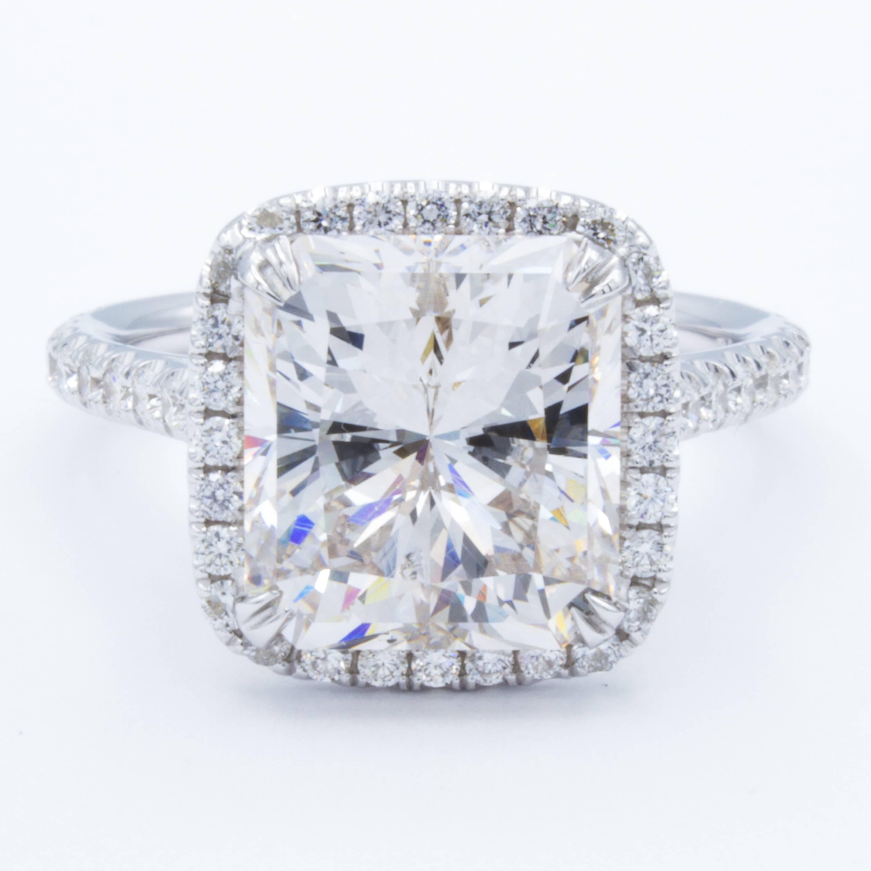 An exceptional Rosenberg Diamonds & Co. diamond engagement ring flaunts a GIA certified 5.17 carat radiant cut diamond of rare beauty. All around the center stone shine round brilliant diamond pave accents that continue into the 18Kt white gold
