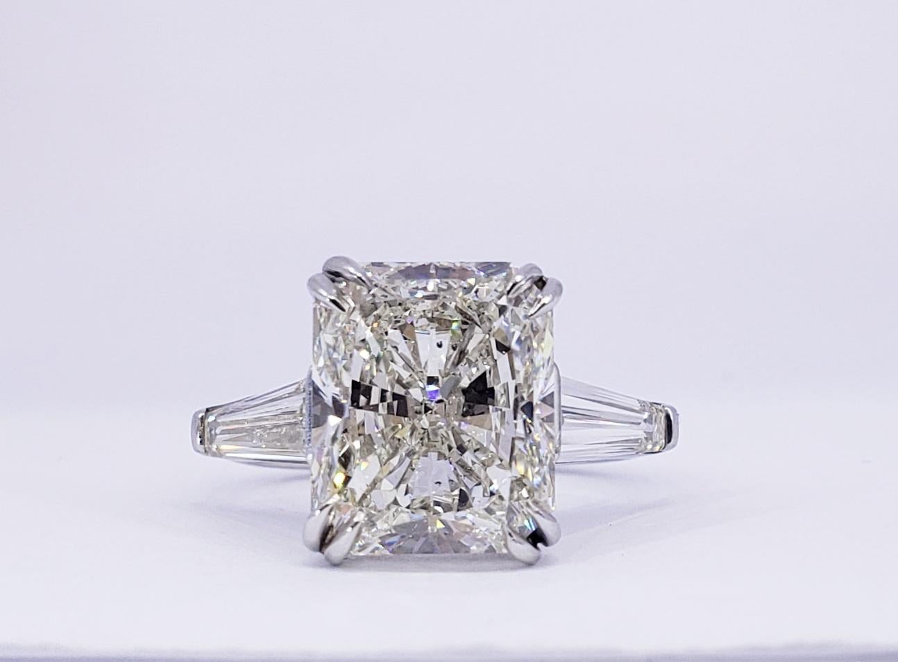 Rosenberg Diamonds 6.05 carat Radiant cut J color SI2 clarity is accompanied by a GIA certificate. This exceptional SI2 Radiant is full of brilliance and it is set in a handmade platinum setting with perfectly matched pair of tapered baguette side