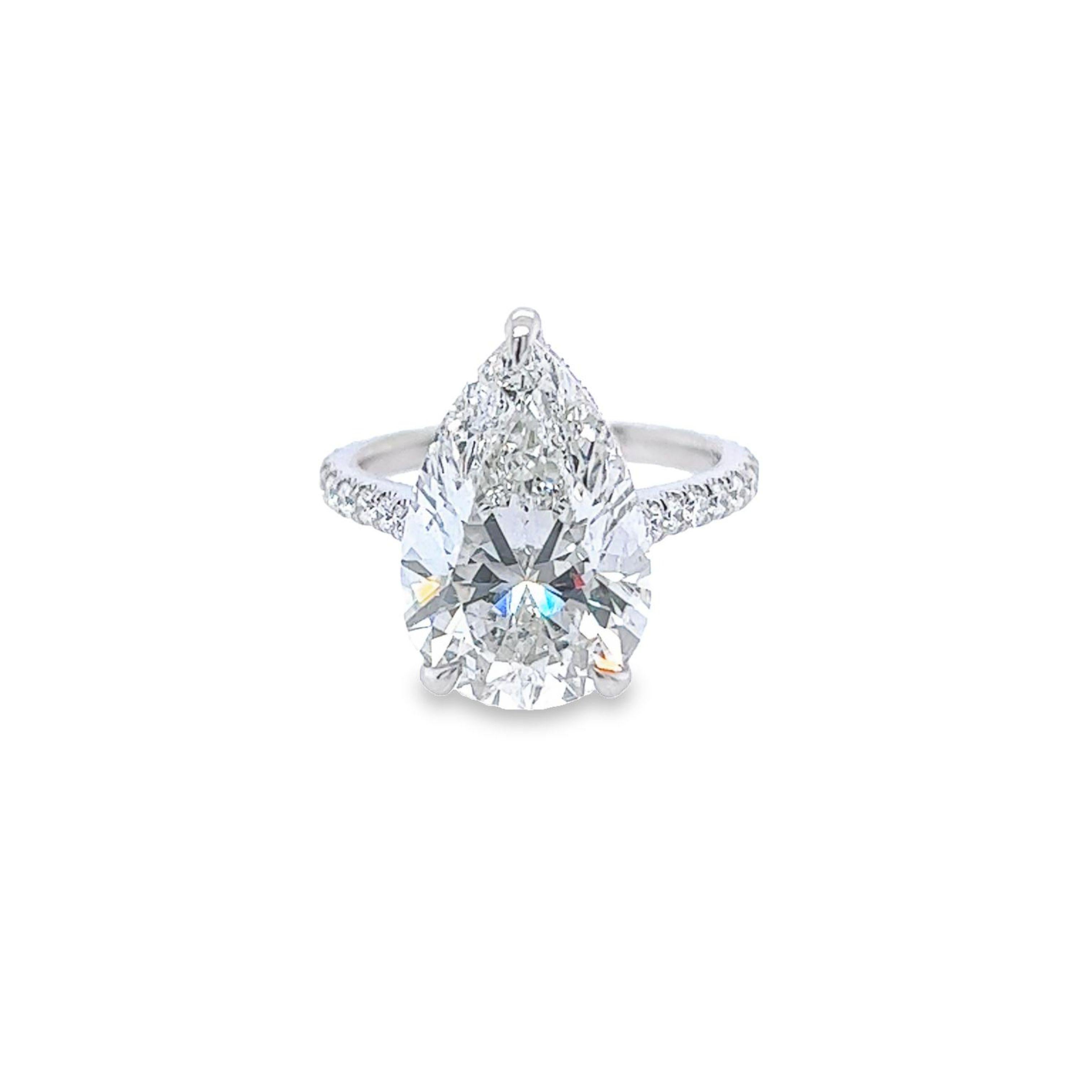 Rosenberg Diamonds & Co. 7.04 carat Pear shape H color SI1 clarity is accompanied by a GIA certificate. This Exceptional SI1 Pear shape is full of brilliance and it is set in a handmade platinum setting. This ring continues its elegance with a