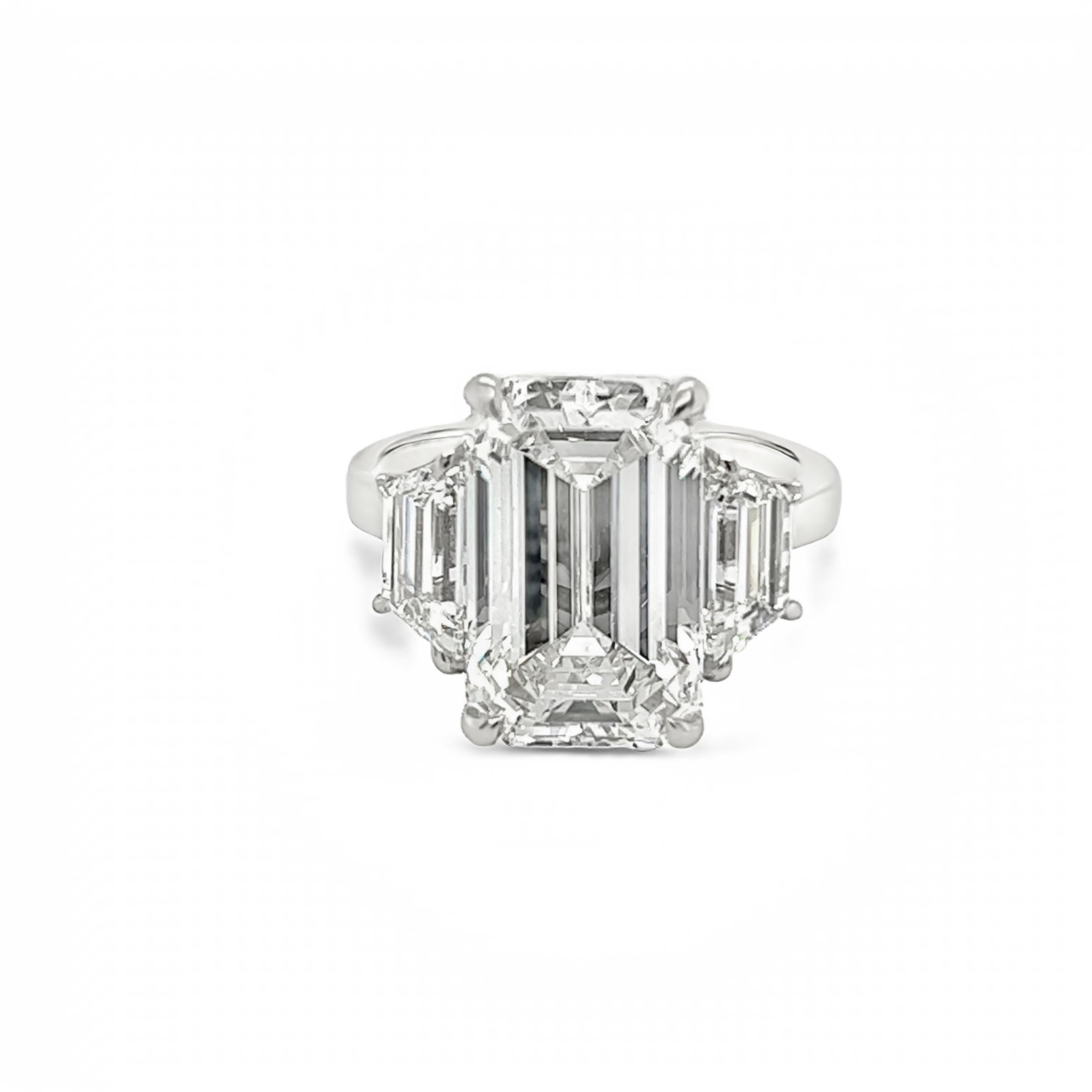 Rosenberg Diamonds & Co. 7.27 carat Emerald cut H color VS1 clarity is accompanied by a GIA certificate. This spectacular Emerald is set in a handmade platinum setting with perfectly matched pair of trapezoid side stones flanking on both sides with