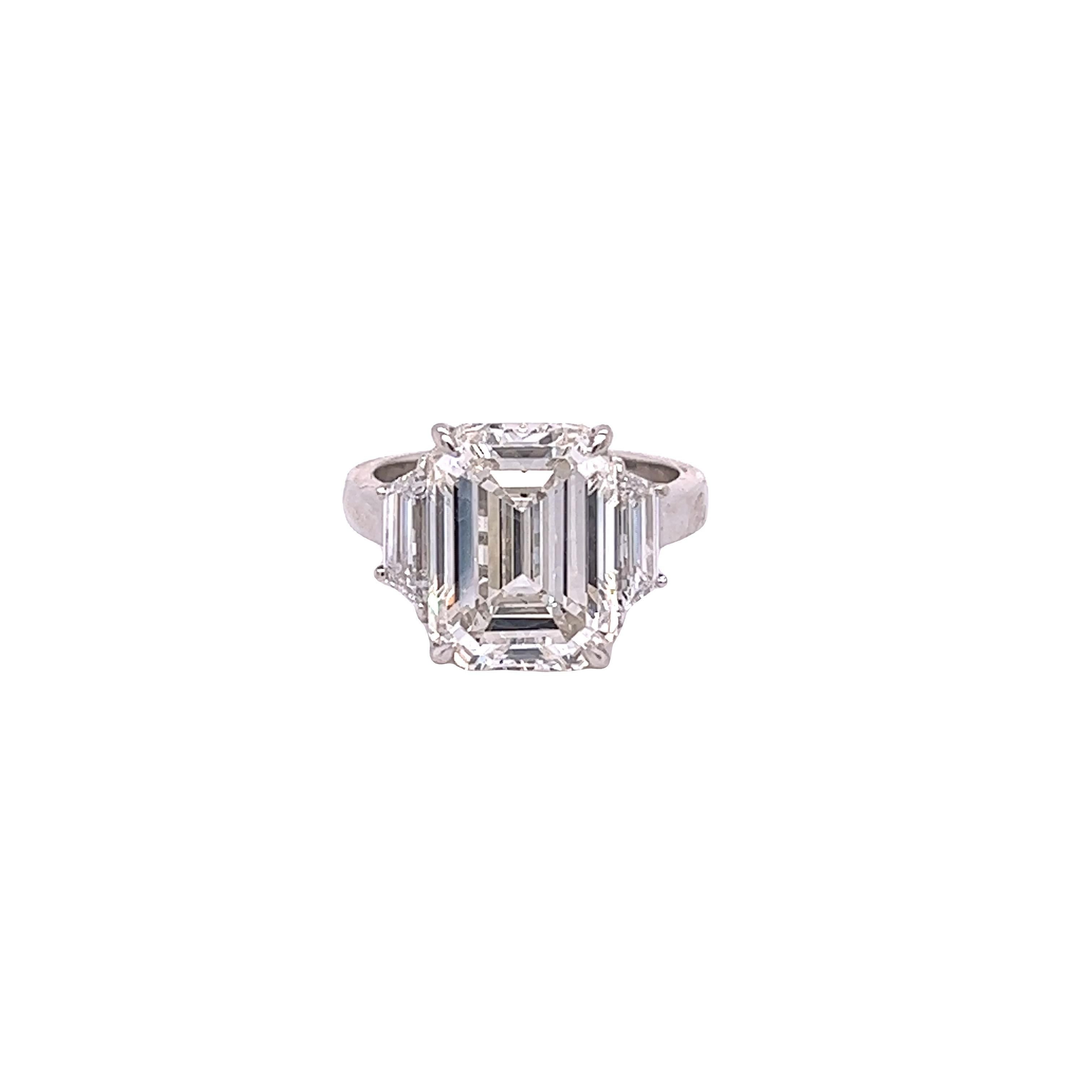 Rosenberg Diamonds & Co. 7.94 carat Emerald cut J color SI2 clarity is accompanied by a GIA certificate. This spectacular Emerald is set in a handmade platinum setting with perfectly matched pair of step cut trapezoid side stones flanking on both