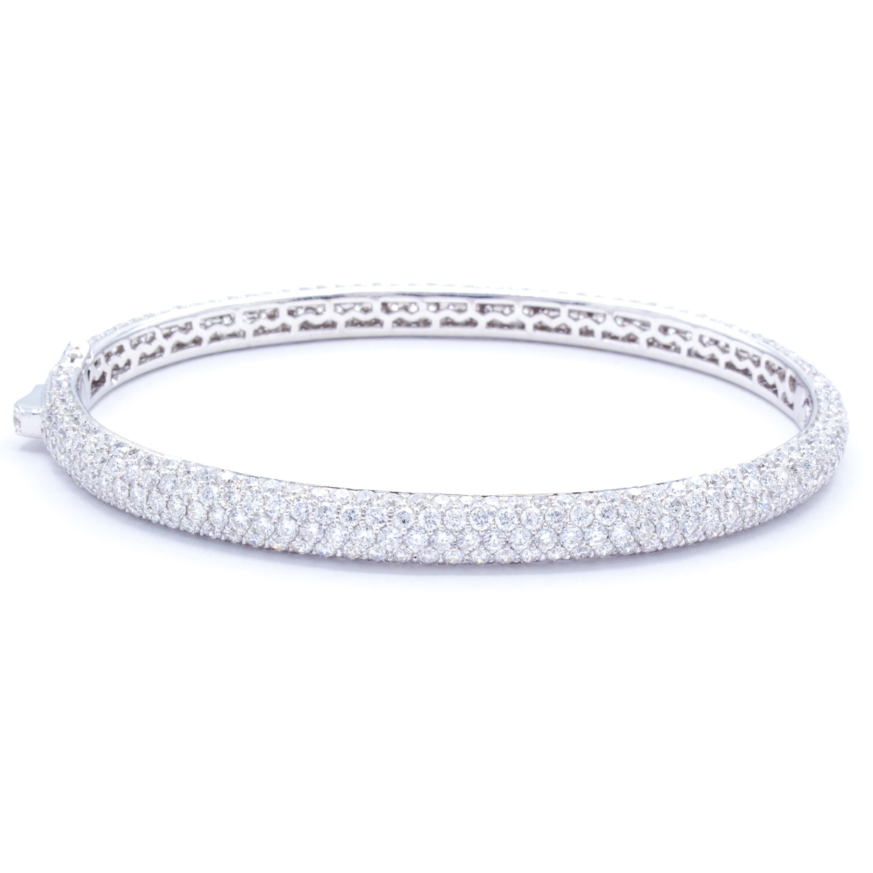 This gorgeous bangle bracelet forms a band of 18Kt white gold upon which are set over 500 round brilliant diamonds in a fiery display of color and light. This nearly overwhelming design enchants any viewer with over 8 carats in total spread upon the