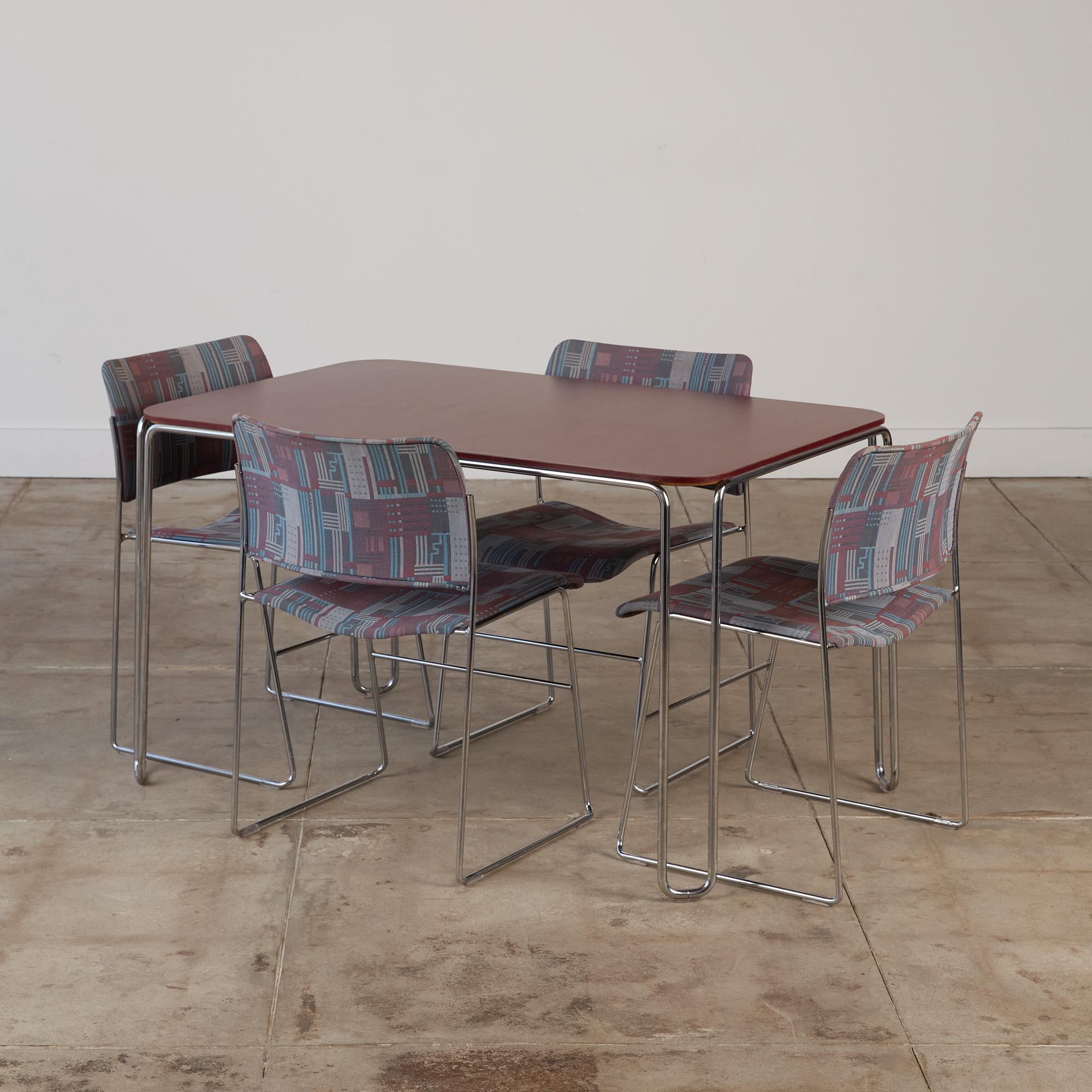 A dining set by David Rowland for GF Furniture Systems, c. 1990. The set consists of a table and four 1963-designed simple and stackable modern set of 40/4 stacking dining chairs. These feature heavy chrome plated steel bases, with molded seats