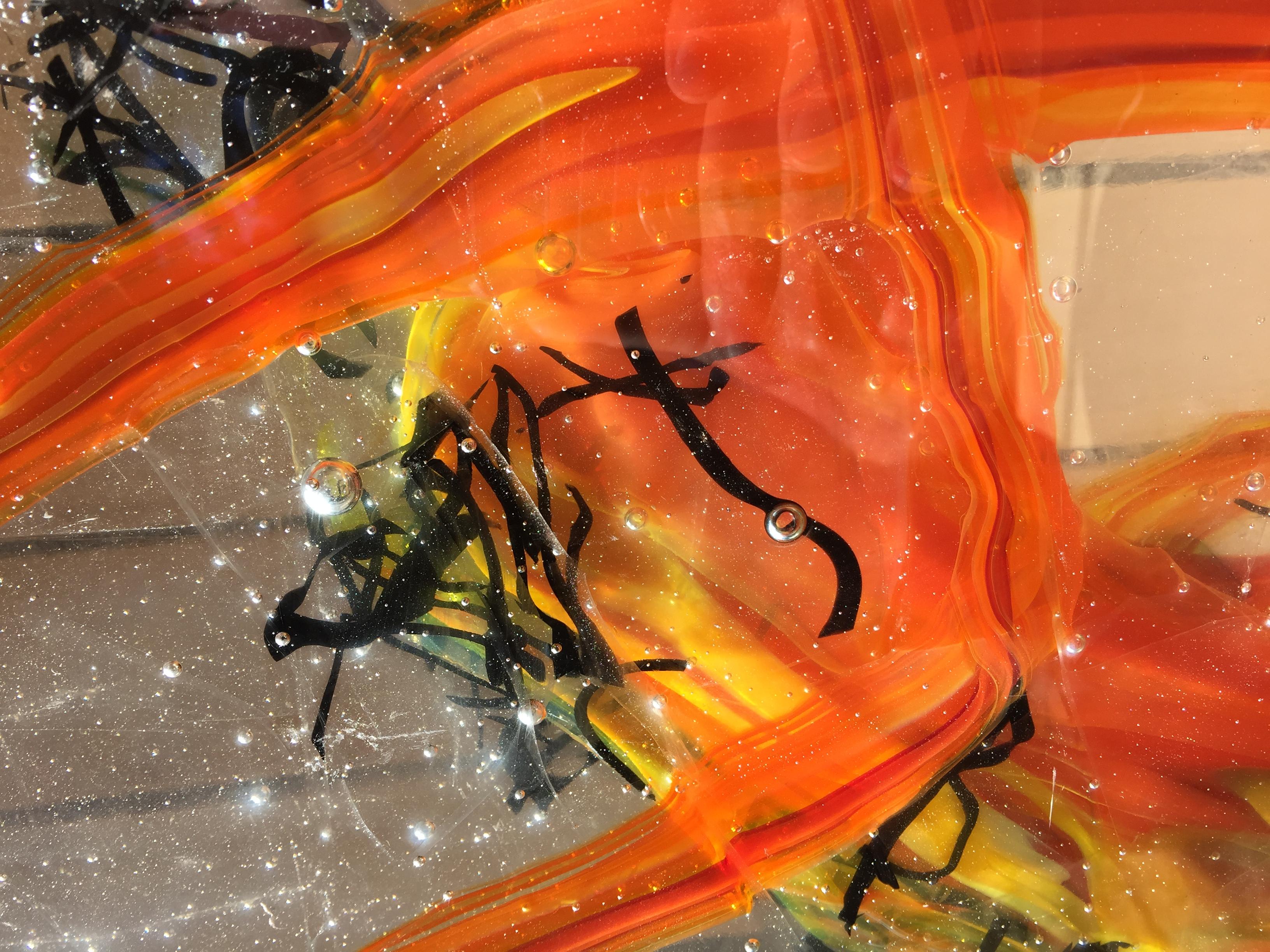 'Gaji' is a contemporary abstract cast glass sculpture by David Ruth from his Internal Space series. It features painterly brushstroke formations in glass called trails. These trails of orange and black are created through rolling molten glass into