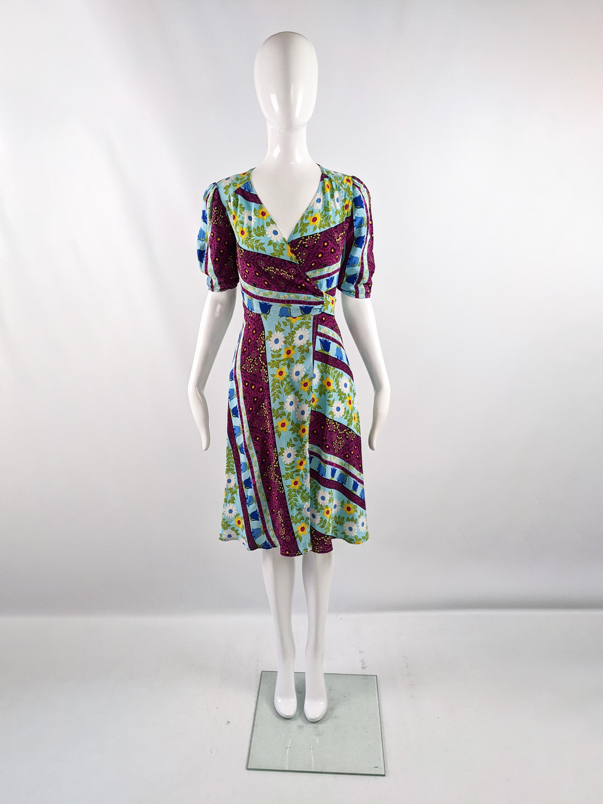 A pretty vintage womens short puff sleeved dress from the 70s by quality British boutique fashion designer, David Silverman. In a brightly multicolored rayon fabric with a bold bohemian floral print design throughout. Perfect for a festival or for