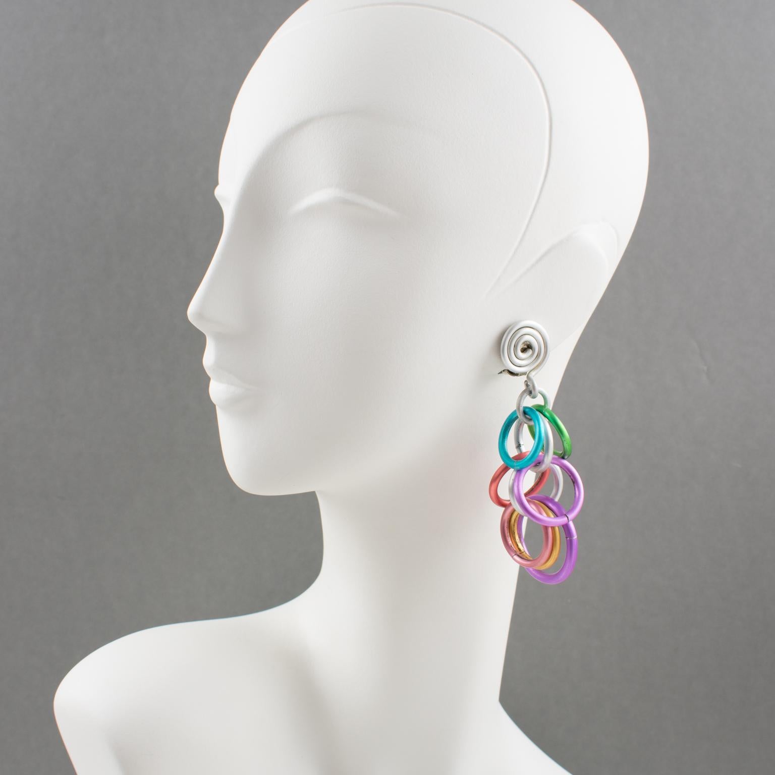 Lovely David Spada, New York signed dangling clip-on earrings. Featuring a cool Space Age 1980s design with a dangle articulated spirally coiled element along with assorted size rings. Anodized aluminum metal with rich pastel colors (silver, green,