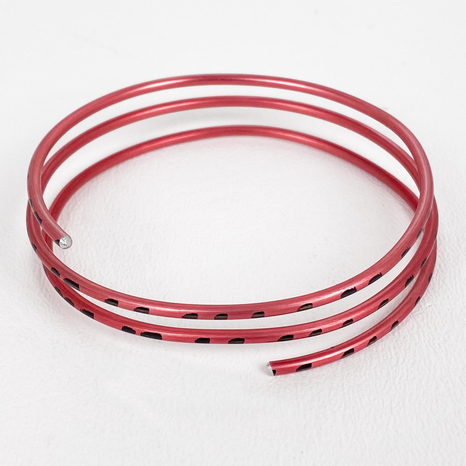 Questo splendido braccialetto a spirale modernista di David Spada &New York è caratterizzato da un design anni '80 in stile A Space AGE. Il braccialetto ha una forma a spirale in alluminio anodizzato rosa decorato con punti neri. Non c'è una firma