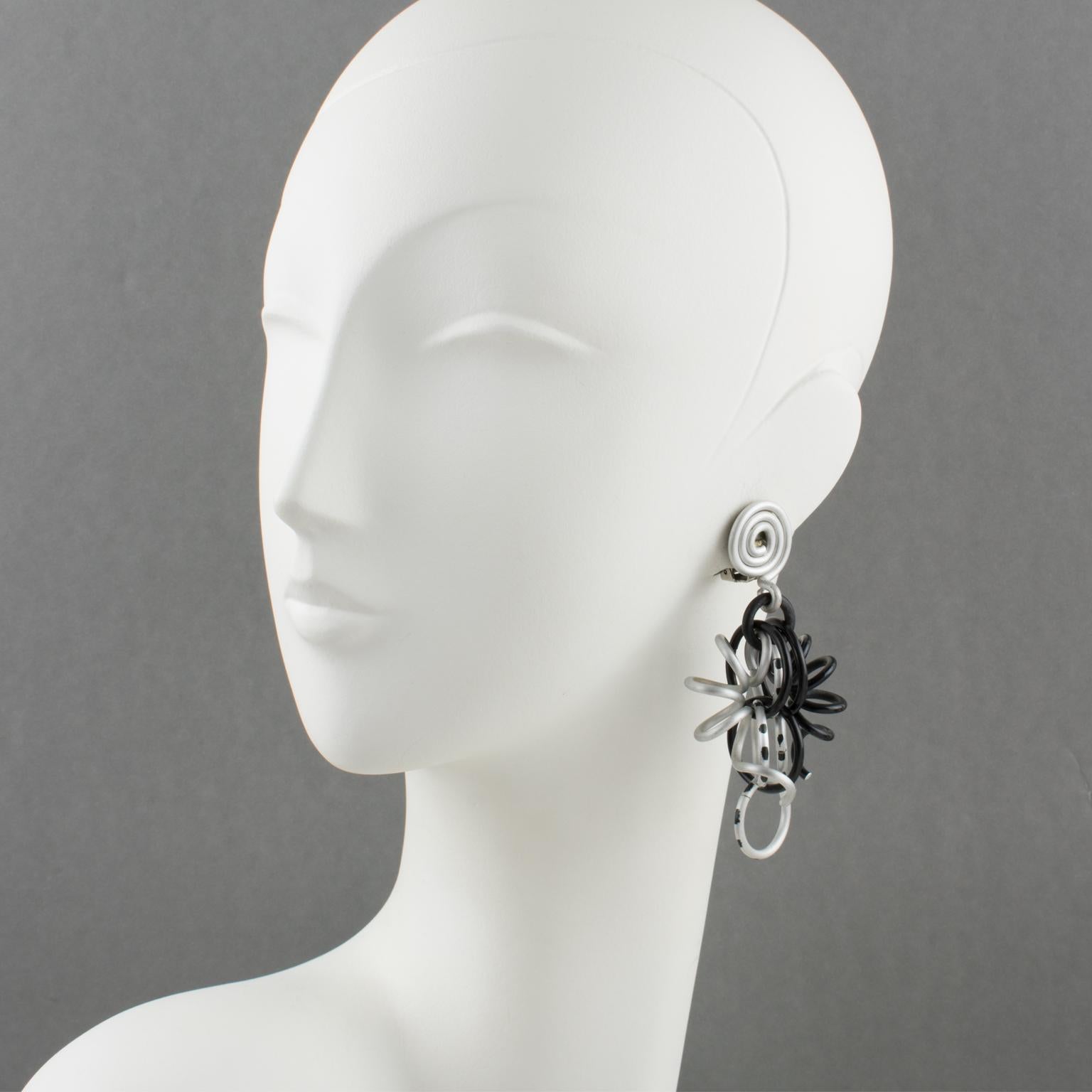 Elegant David Spada, New York signed dangling clip-on earrings. Featuring a cool Space Age 1980s design with dangle articulated spirally coiled elements along with assorted size rings. Anodized aluminum metal with classy colors (black and silver).