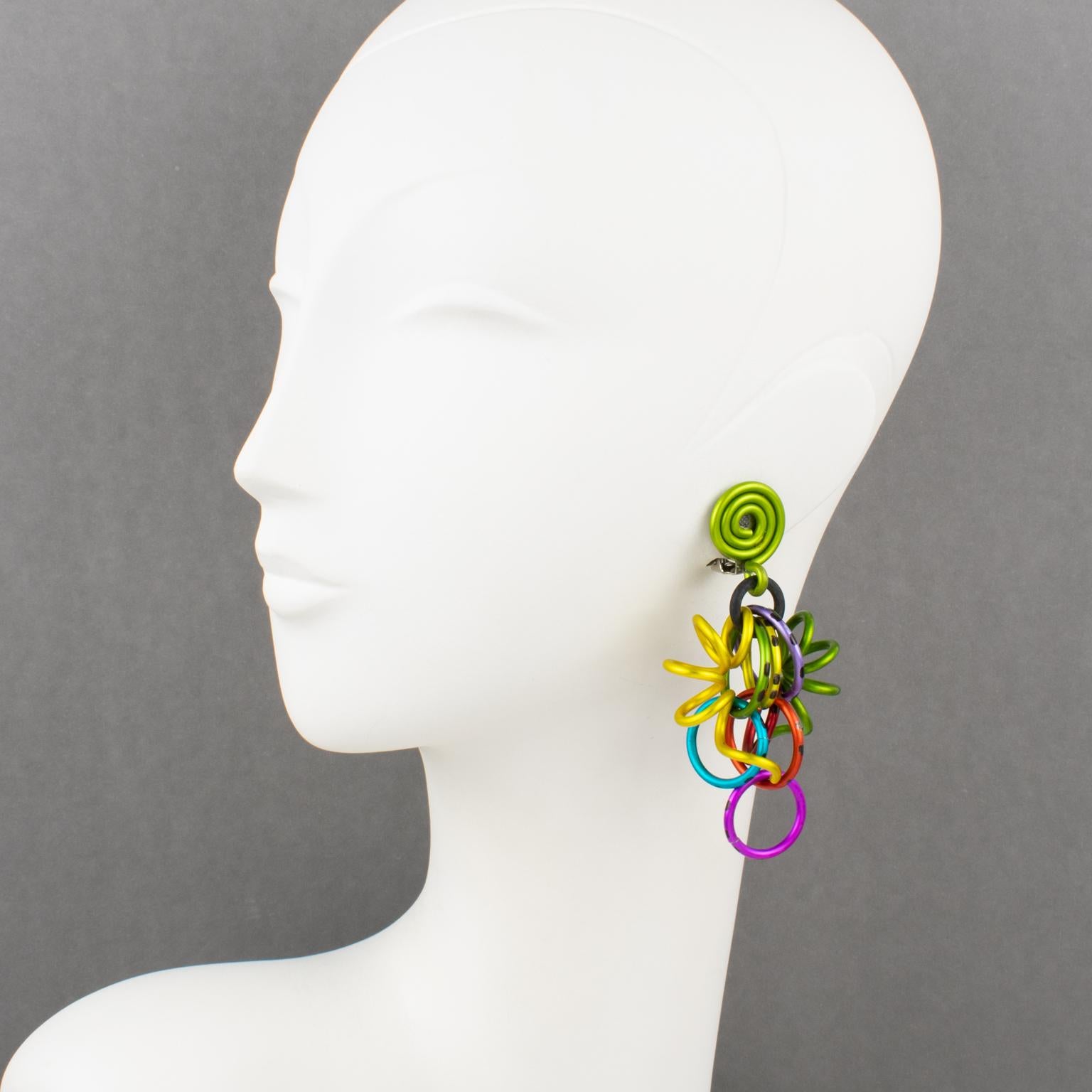Incredible David Spada, New York signed dangling clip-on earrings. Features a cool Space Age 1980s design with dangle articulated spirally coiled elements along with assorted size rings. Anodized aluminum metal with rich bright colors (avocado