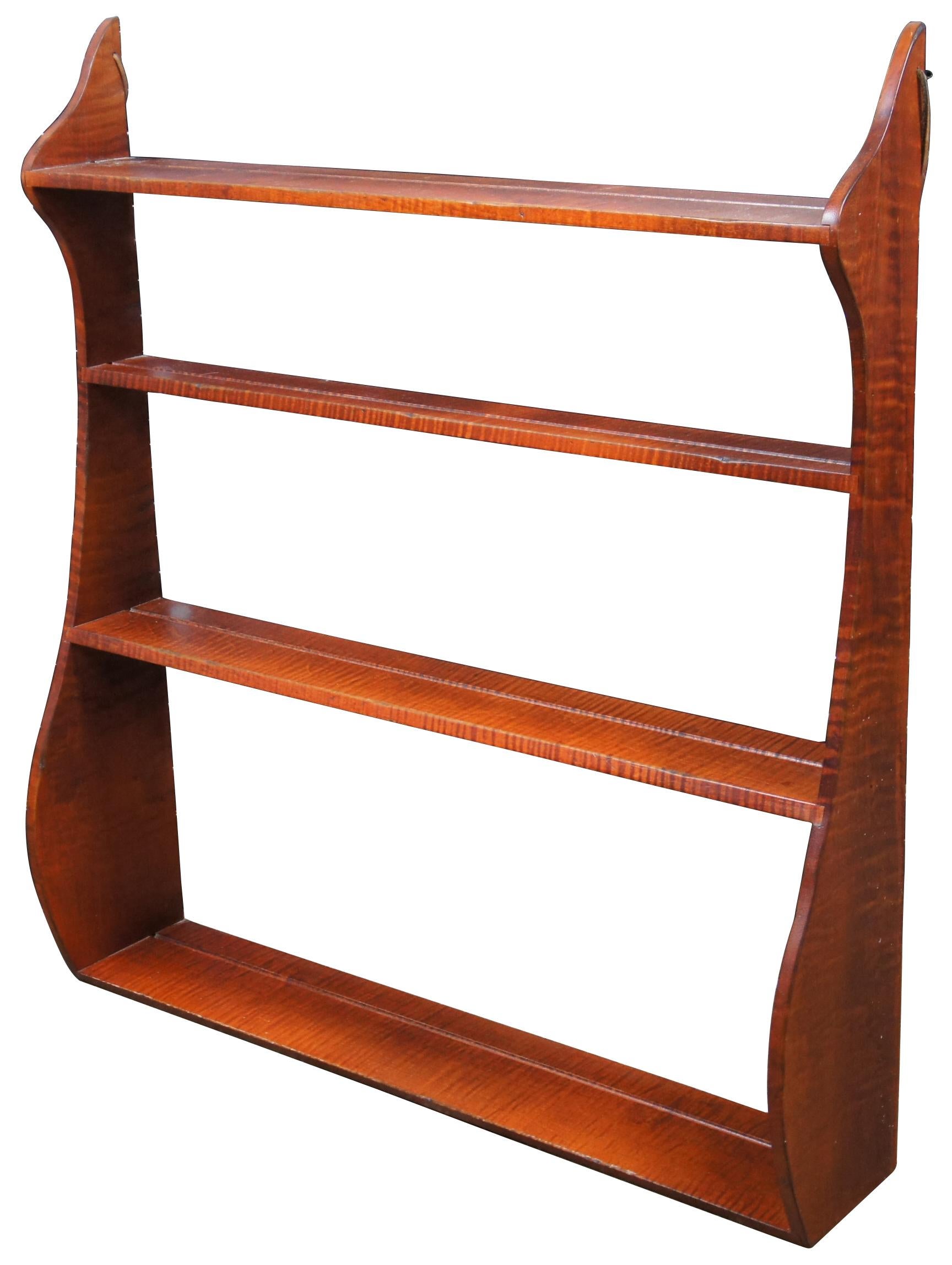 Vintage curly maple whale shelf display with plate grooves by David T Smith. Features four shelves, serpentine shape and leather loops for hanging. Measure: 30