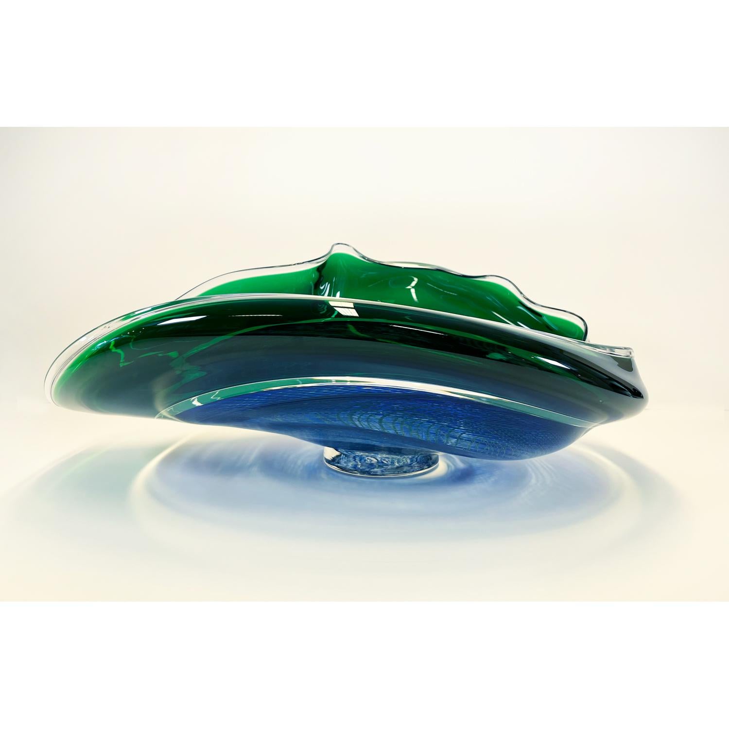 This Blue/Emerald Rondelle Bowl is a continuation of David's work with cane. Fusing his signature wave bowl motif with his newer rondelle cane pattern. This beautiful glass bowl is sure to be a showstopper in your space. 

David Thai is a Chinese