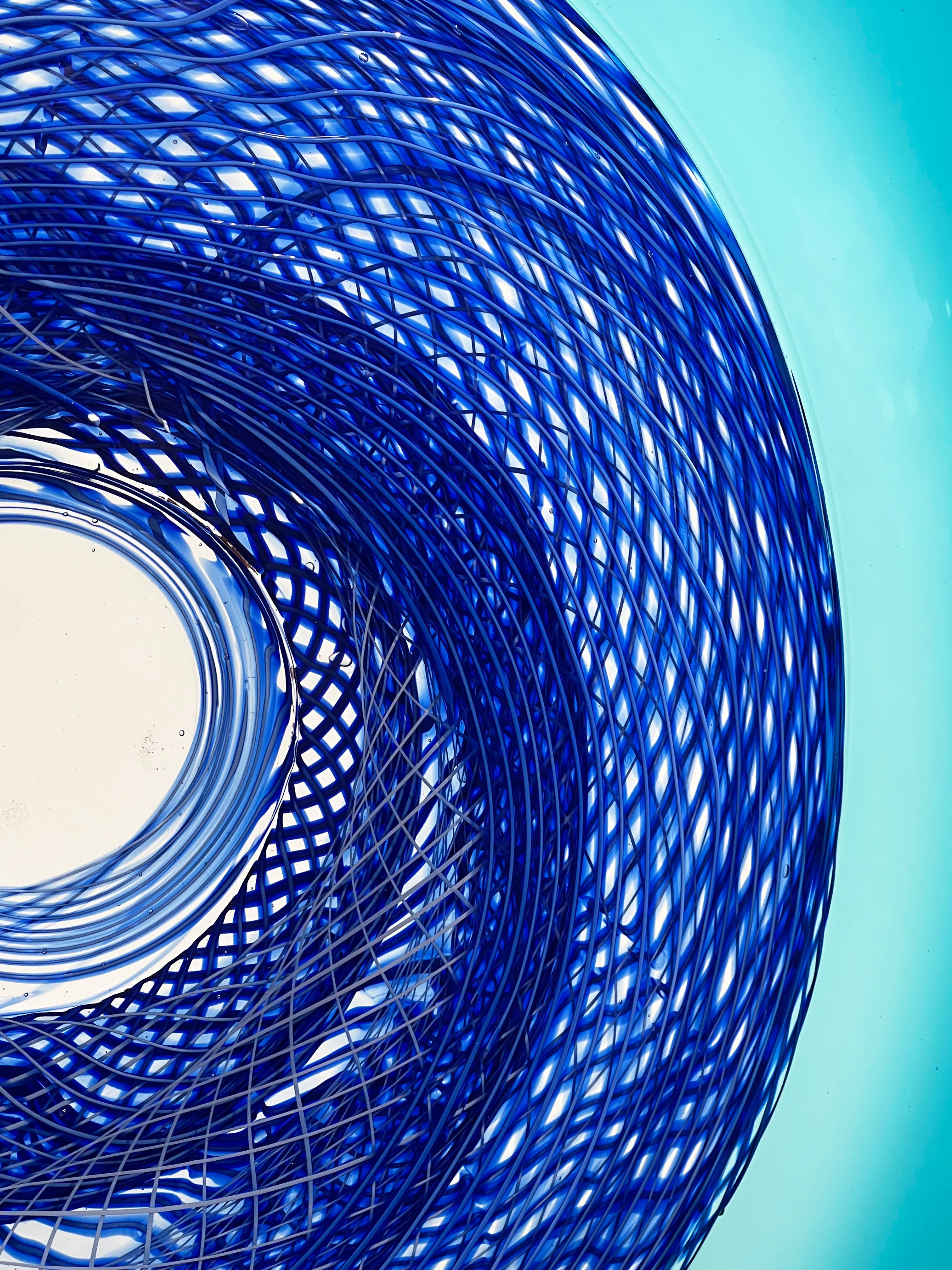 Blue Rondelle is a large scale glass and metal sculpture. The glass is a beautiful light blue that is met towards the middle with spiraling lines of vibrant cobalt glass cane.

David Thai is a Chinese Canadian Glass Artist who emigrated from Vietnam