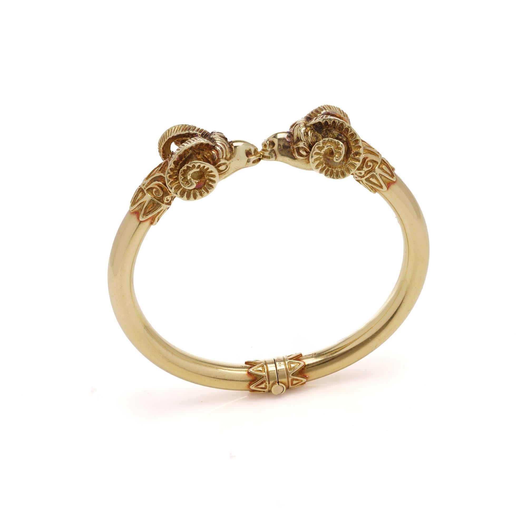 David Thomas 18kt yellow gold bangle bracelet bangle with joined ram heads.

Dimensions: 
Weight: 72 grams 
Inner width: 6.3 cm 

Design Elements - 

Material: The bracelet is made of 18kt gold. 
Motif: The central design features two joined ram
