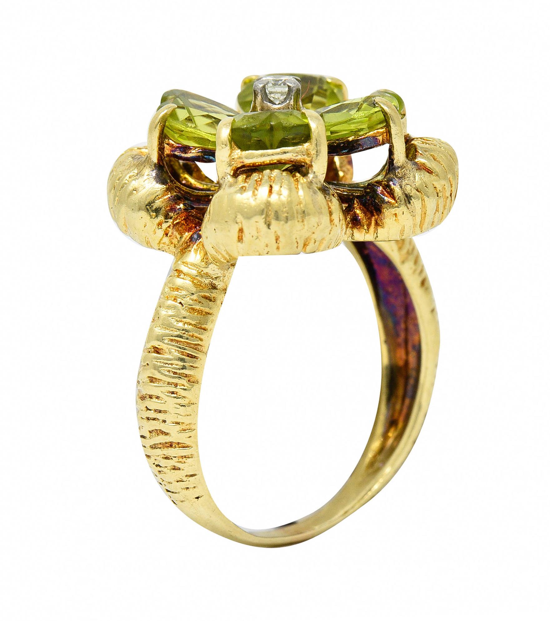 Designed as a stylized clover comprised of heart cut peridot petals

Very well matched and strongly yellowish green while weighing in total approximately 2.80 carats

Centering a round brilliant cut diamond weighing approximately 0.10 carat - eye