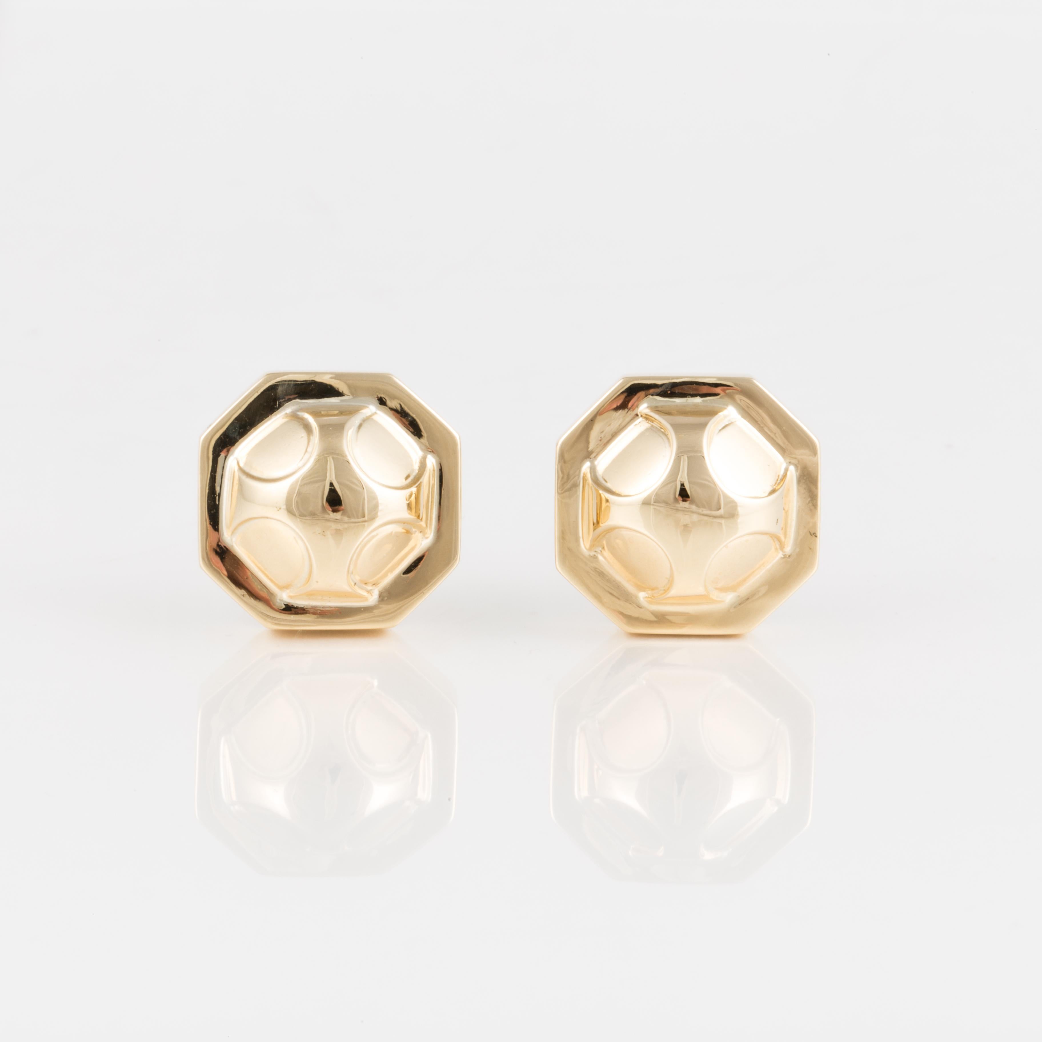 Estate David Webb earrings in 18K yellow gold button ear clips in an octagonal shape with an engraved dome in the center.  Measuring 3/4 inches across and stand 3/8 inches off the ear.  Clip-on style.