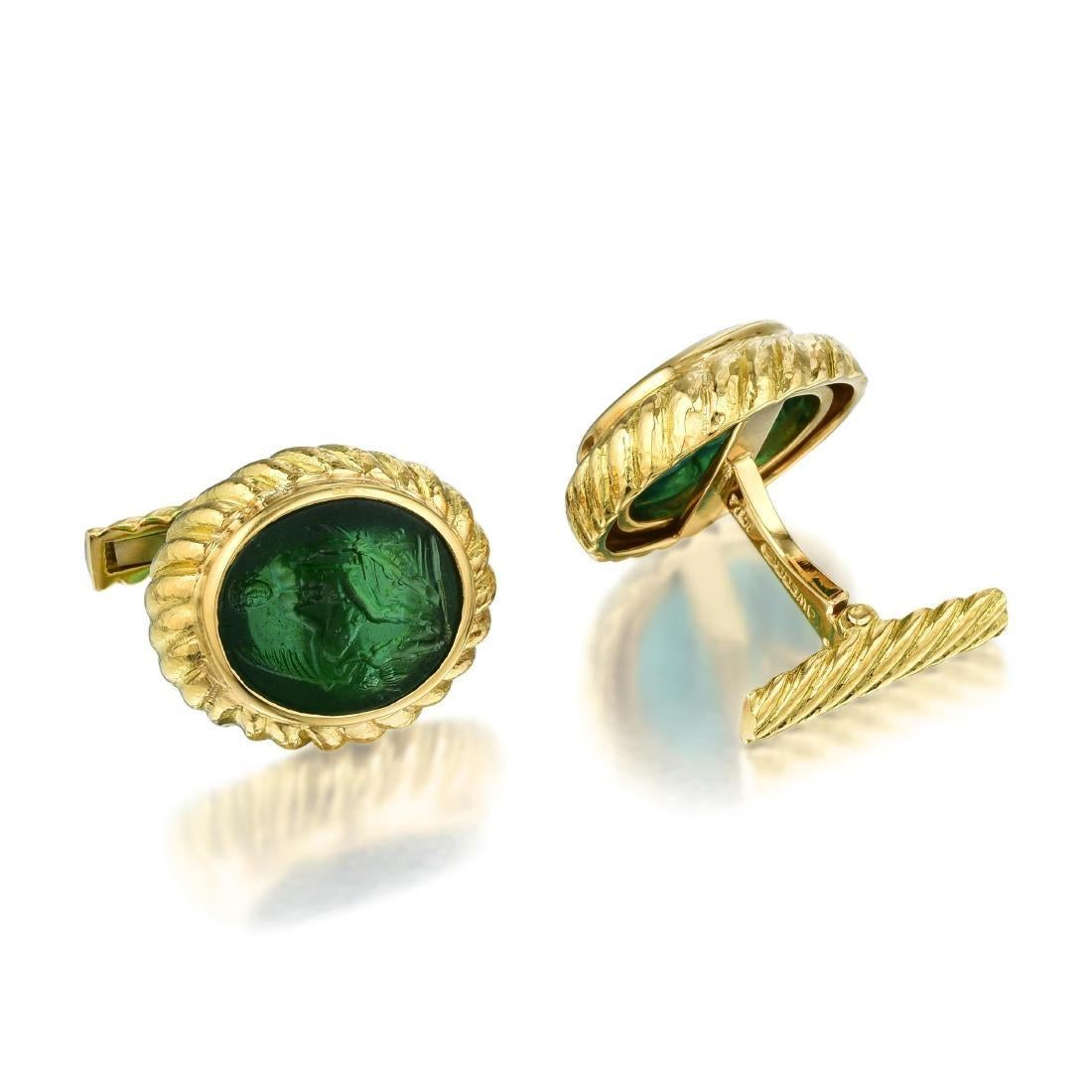 David Webb cufflinks made out of 18 Karat yellow gold with green carved glass centers featuring mythological figures.