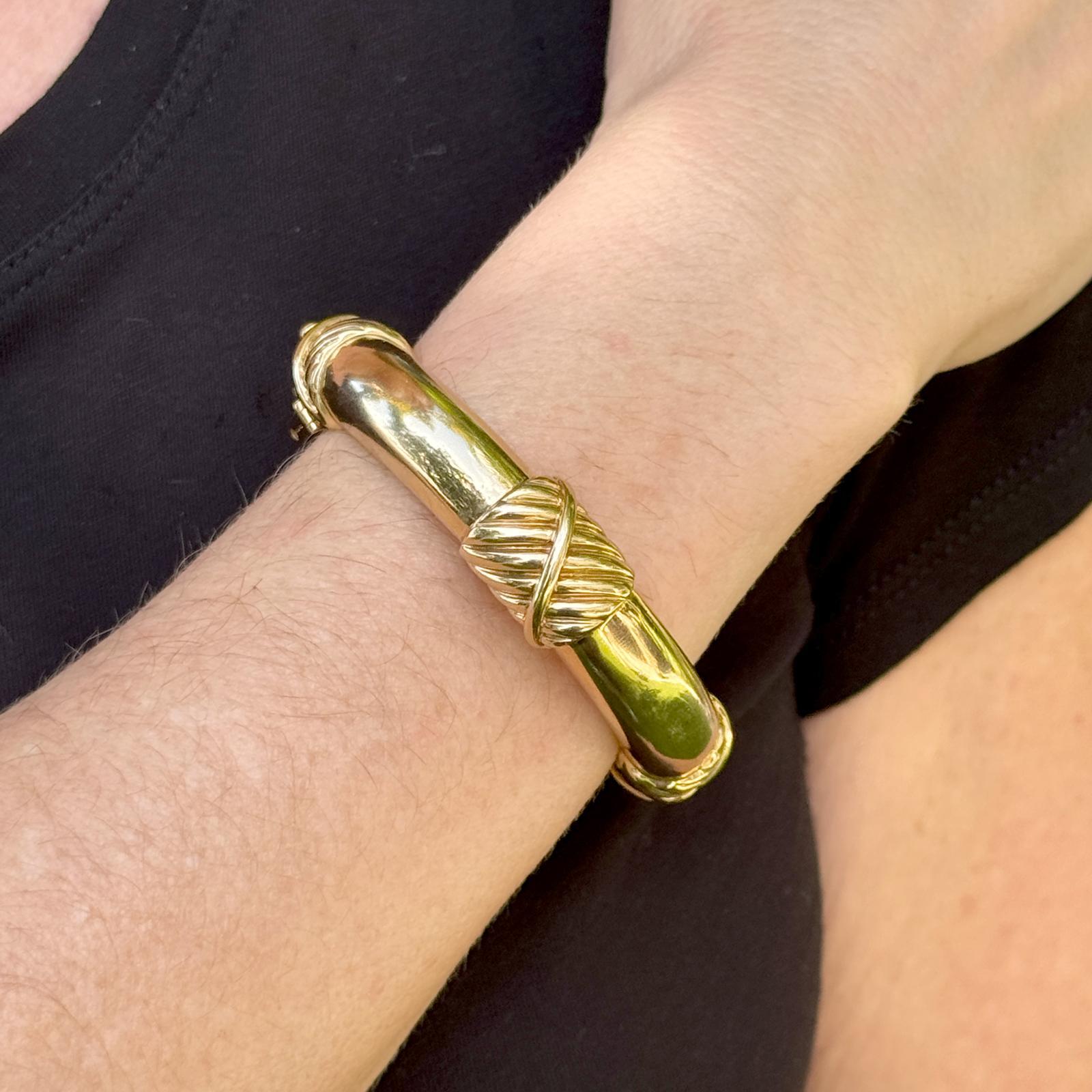 Cet audacieux et élégant bracelet à charnière en or jaune 18 carats de David Webb met en valeur l'esthétique emblématique de la marque. D'une largeur substantielle de 14 mm et d'une circonférence interne de 6,25 pouces, le bracelet s'ajuste