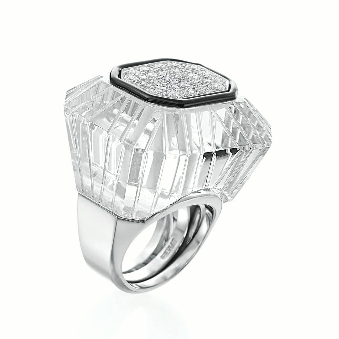 This David Webb 18 karat white gold and platinum ring features carved rock crystal that is accented with 28 round brilliant cut diamonds weighing an approximate combined 1.00 carats with GH coloring and VS clarity. The diamonds are surrounded by a