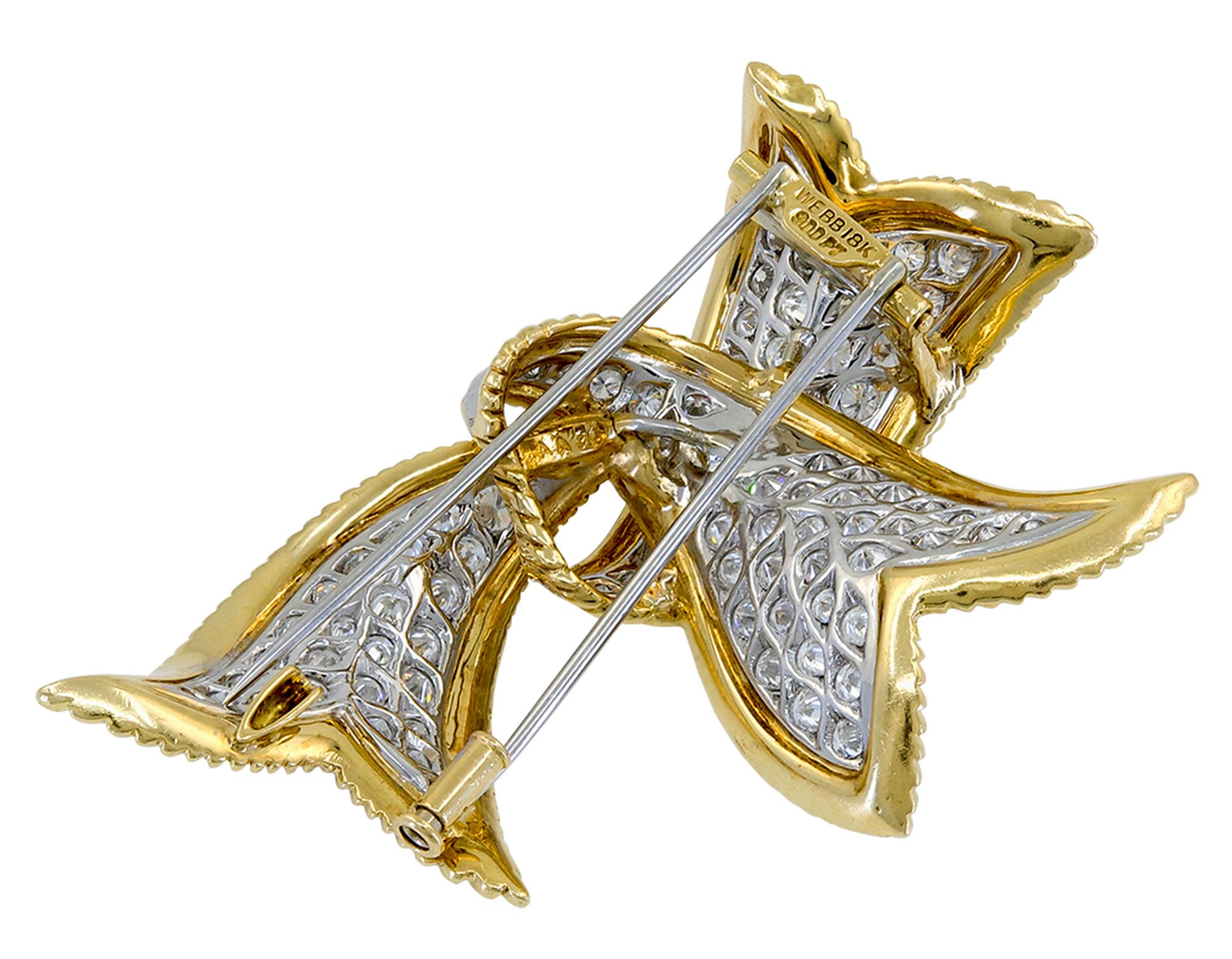Élégante broche en forme de ruban, créée par David Webb, comprenant environ 10,67 carats de diamants taille brillant, de l'or jaune 18K texturé et du platine.
Signé David Webb.
Un certificat d'authenticité est fourni.