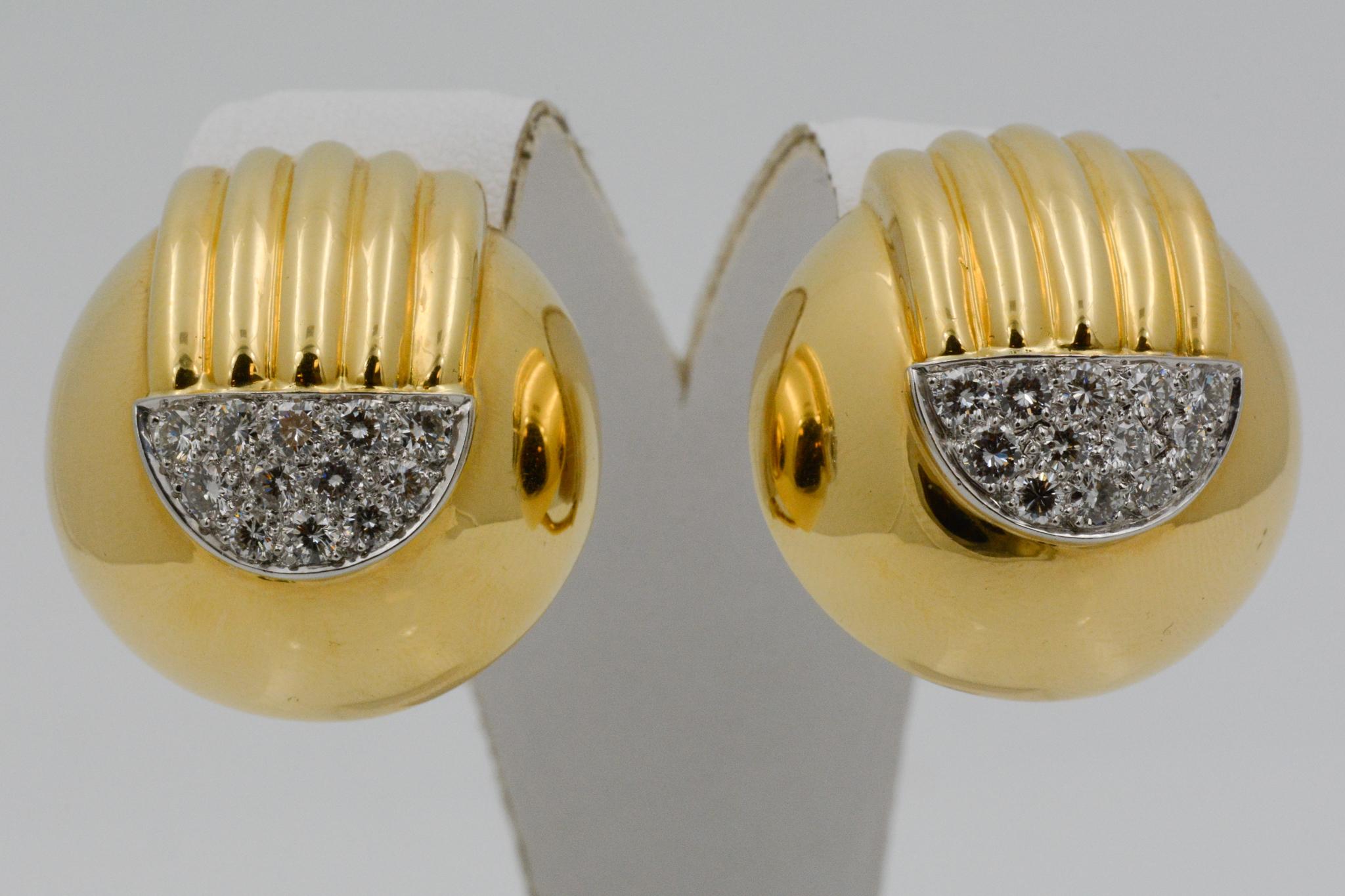 These David Webb clip earrings are 18 karat yellow gold and platinum in a dome shape with a ribbed detail along the top. They are set with 24 round brilliant diamonds weighing an approximate combined 0.75 carats with G color and VS clarity. 