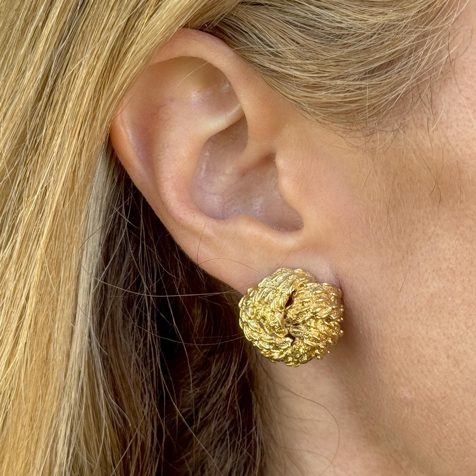Questi eleganti orecchini David Webb sono realizzati in oro giallo 18 carati e platino con un bellissimo design a nodi e la caratteristica finitura strutturata. Con un diametro di 20 mm, sono dotati di chiusure a leva sicure per essere indossati