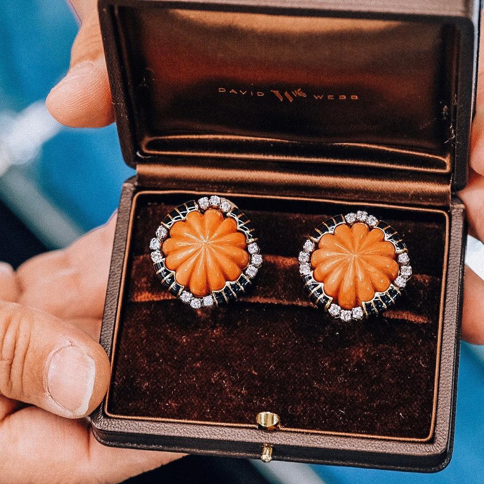 A pair of contemporary 18 karat gold and platinum earrings with diamonds and carved corals by David Webb. Each earring centers one fluted carved coral surrounded by round brilliant-cut diamonds with an approximate total weight of 0.30 carats,