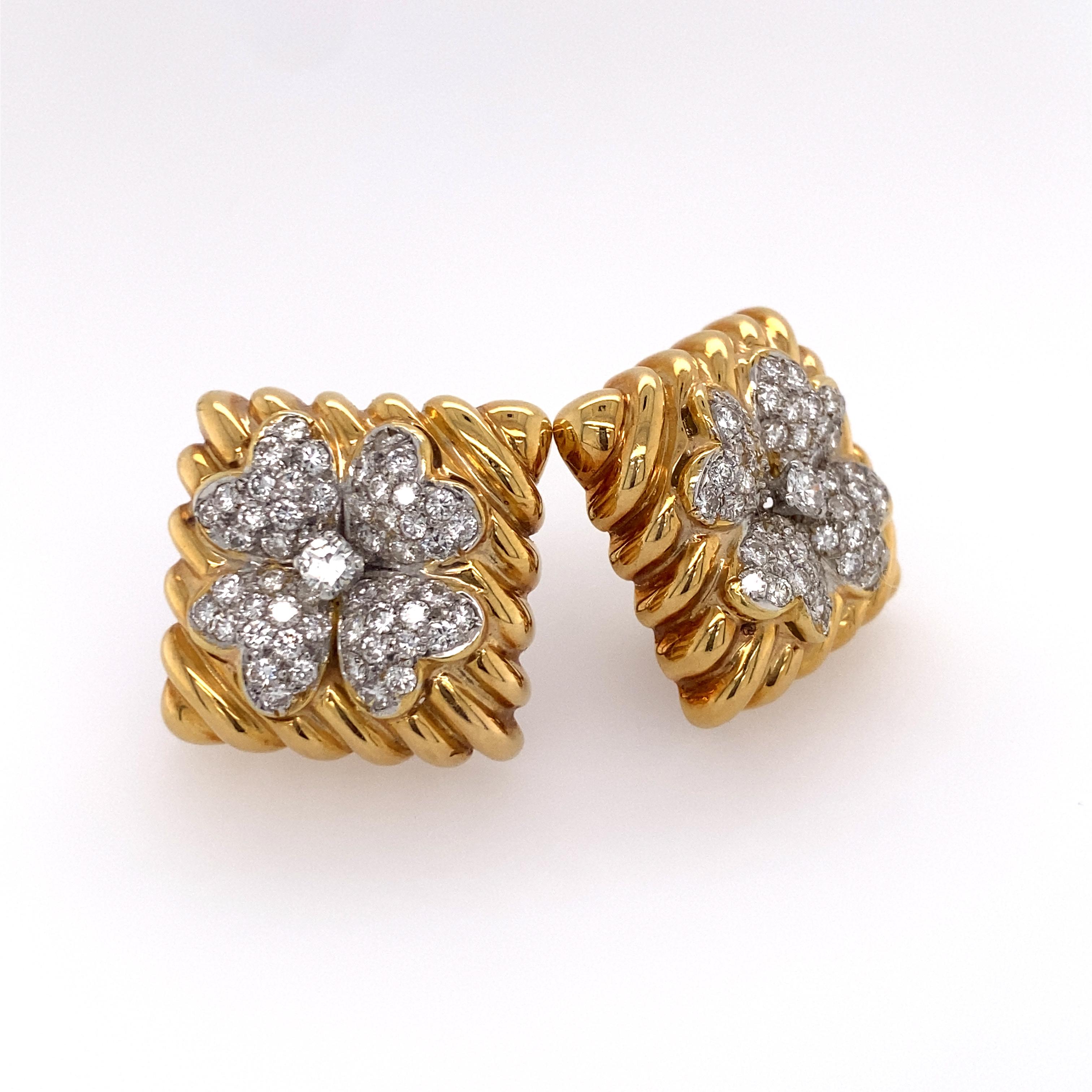 Pair of 18k gold earrings by David Webb, the  square fluted ear clips each featuring a four-leaf clover design centering a round brilliant-cut diamond weighing approx. 0.15 ct. framed by pave-set full-cut diamond leaves; approx. 3.75 tcw.; signed;