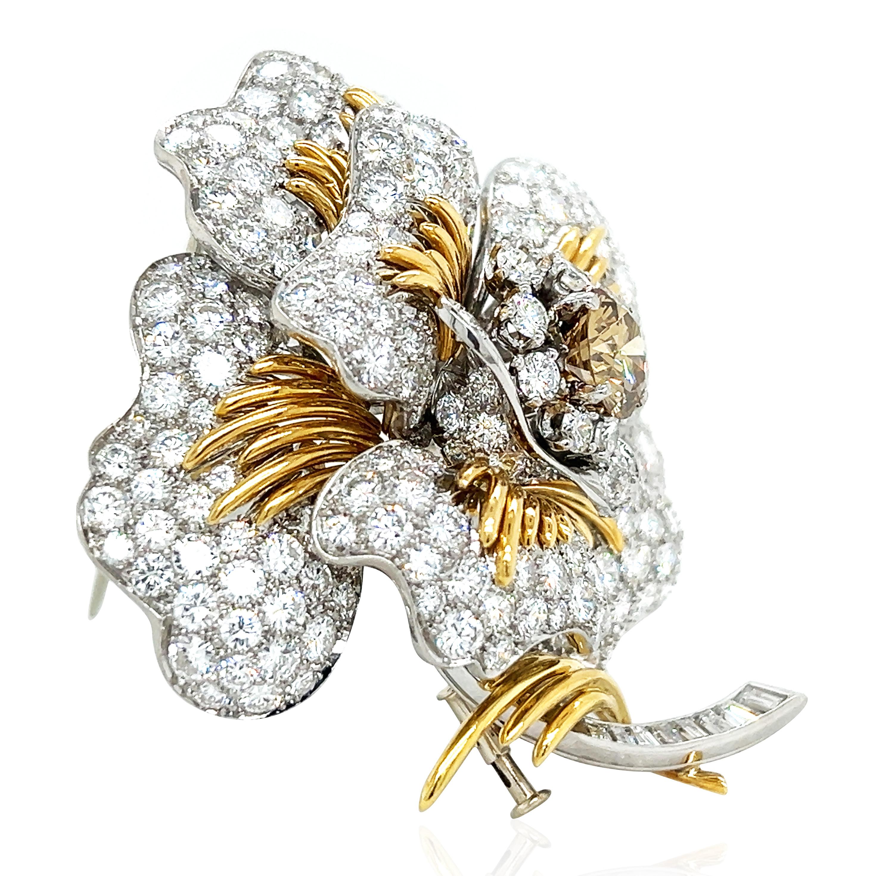 This David Webb diamond flower brooch showcases ultimate luxury and craftsmanship, with delicate diamond pavé petals and a clever mix of gold and platinum, forming a magnificent flower. The centerpiece features a 2.3ct diamond, surrounded by