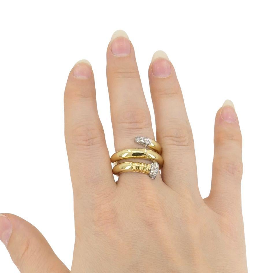 This modern ring by David Webb features a bold nail wrap design, crafted in 18k yellow gold and platinum. The ring is set with 27 round brilliant-cut diamonds, totaling approximately 0.75 carats. The design wraps fluidly around the finger, with