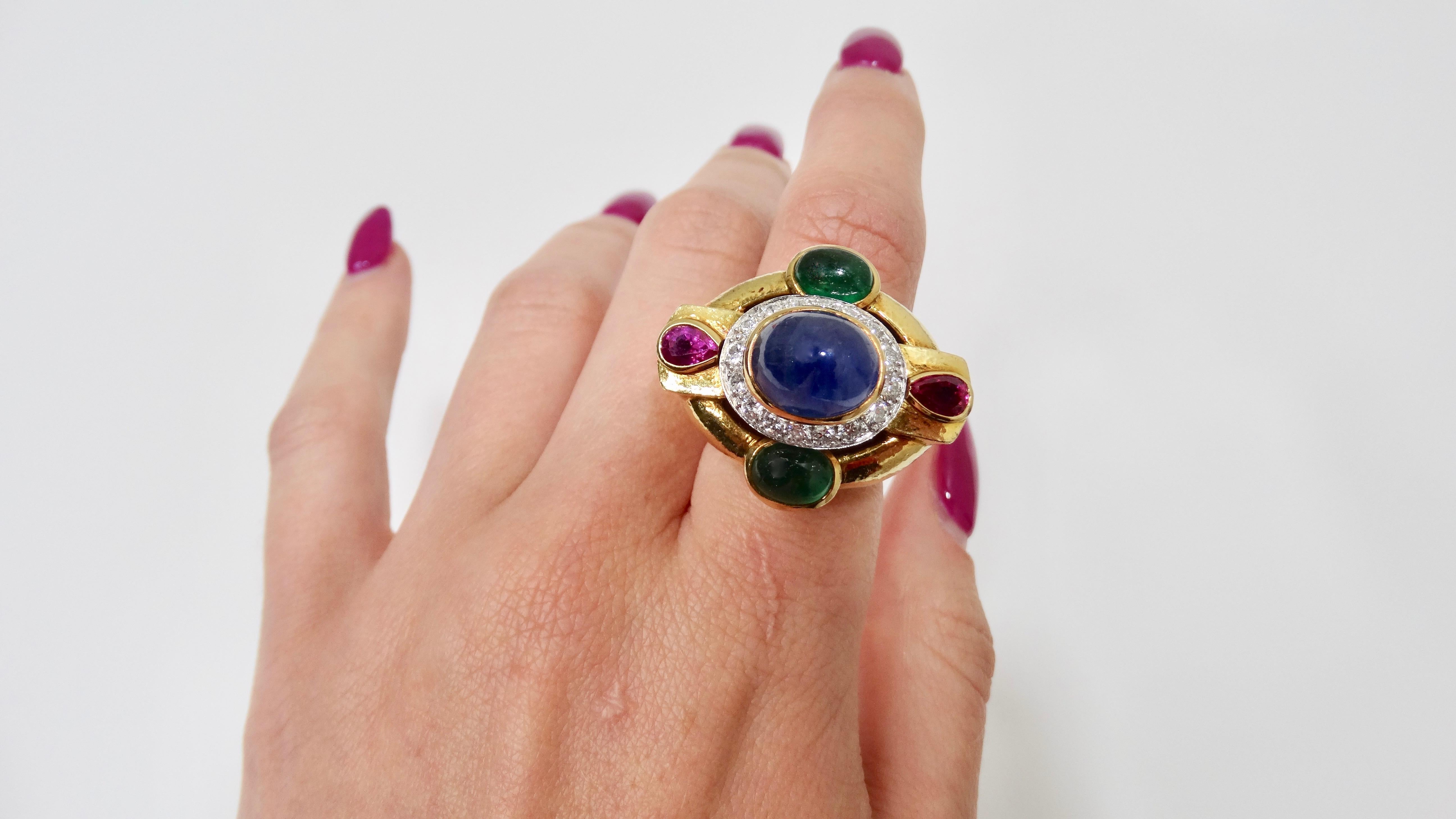 Elevate your evening look with this stunning David Webb Cocktail ring! This cocktail ring features 18KT Yellow Gold with a geometric design containing one oval, cabochon, and very good quality Blue Sapphire measuring approximately 11.50mm x 9.60mm x