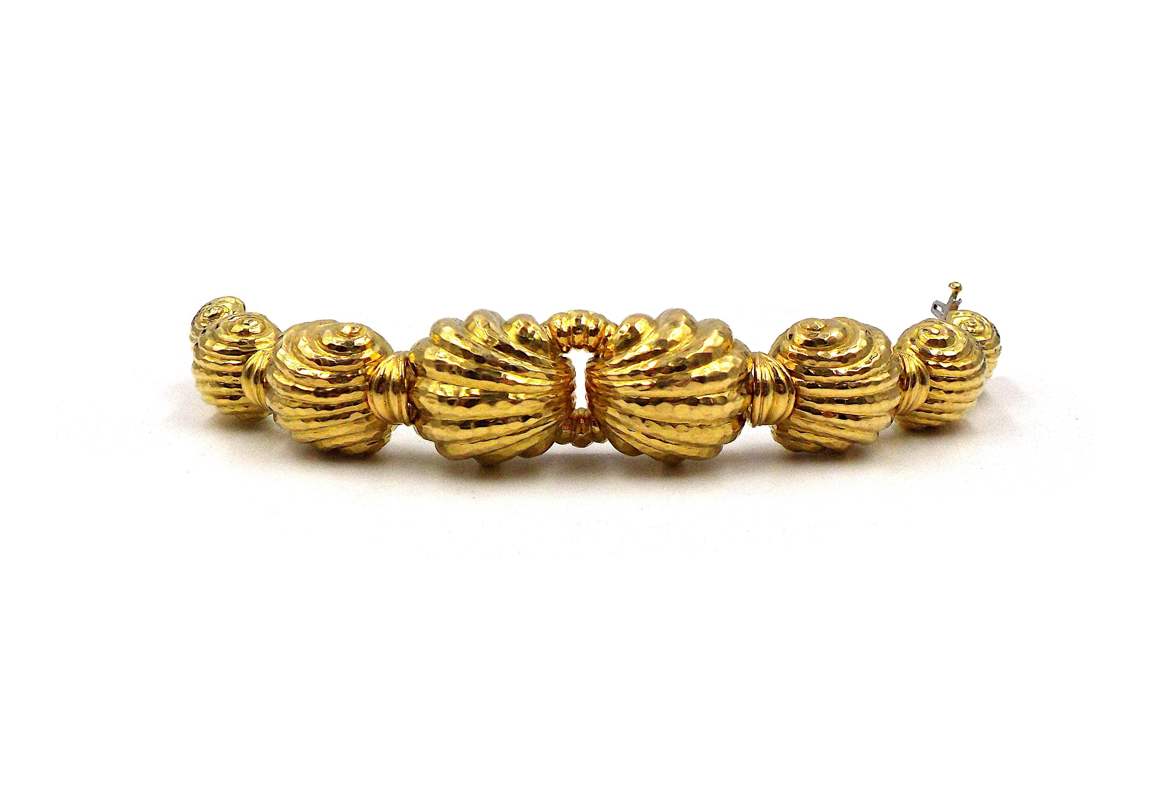 A fancy hammered yellow gold bracelet by David Webb. Signed Webb, marked 18K. Inner circumference is approximately 6.75 inches. 