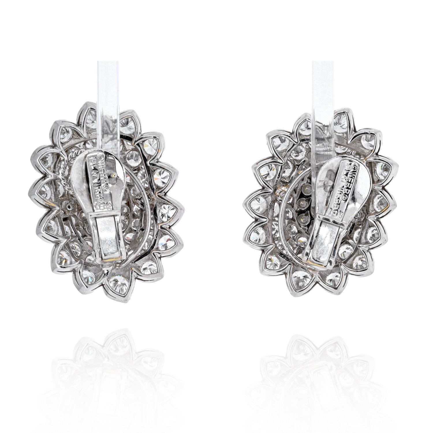 David Webb clusted diamond earrings mounted with a center oval and round cut diamonds. These earrings are crafted mainly in 18K White gold, with some platinum. 
Each earring is set with an oval cut diamond in the center and  within a surround of
