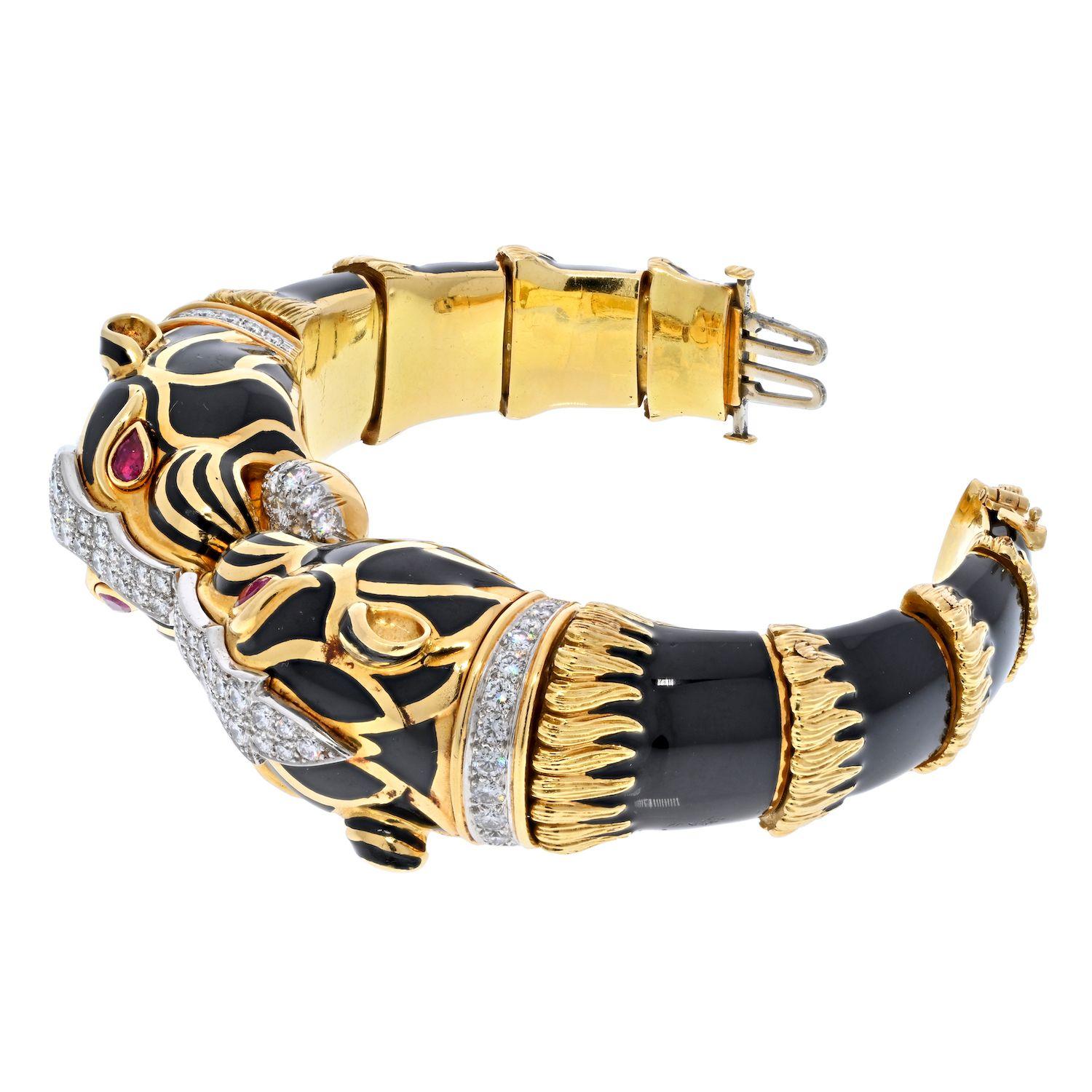 David Webb 18K Yellow Gold Black Enamel Double Head Lion Bracelet.
Wrist size: inner circumference 16.0 cm (6 ¼ in)
Designed as an articulated hinged bangle, the two opposing black enamel panthers, with bezel-set ruby eyes and a circular-cut diamond