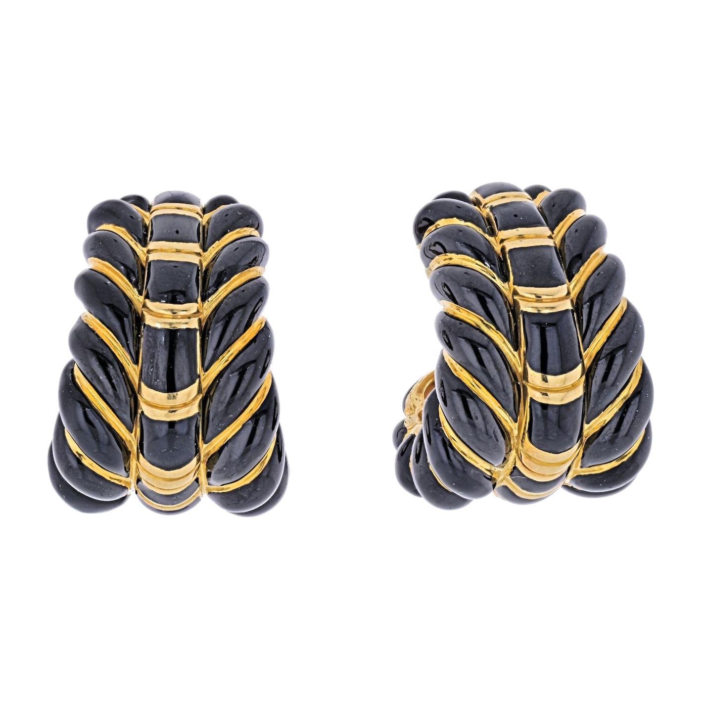 A pair of black enamel tapered hoop ear clips, David Webb. Designed as diagonal bombe bands applied with black enamel, spaced by slender gold bands.
Heavy clip-on backs. 
Crafted in 18k yellow gold. 
L: 31mm
W: from 16mm to 23mm