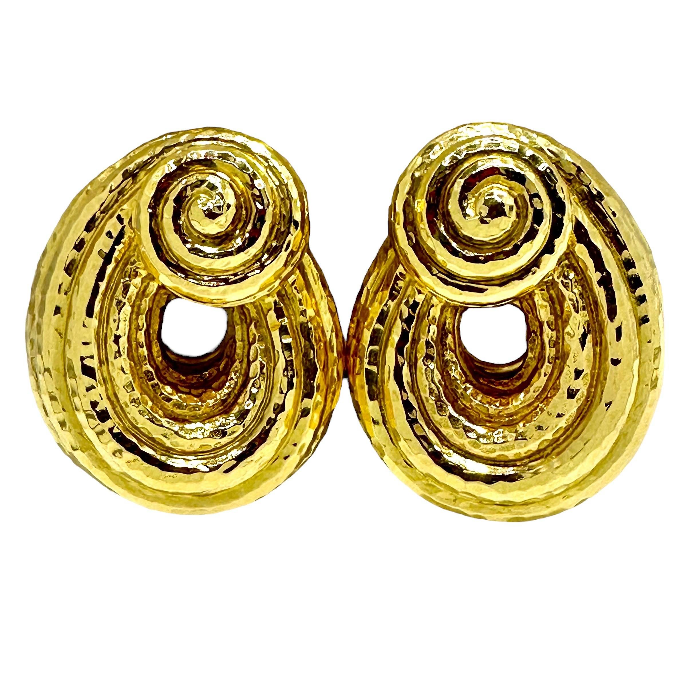 This wonderful, large and visceral pair of David Webb 18K yellow earrings are a product of the 1960's. The pair are very dimensional and have a heavily hammered finish on all surfaces. At the top are scroll motifs from which are draped open swags.