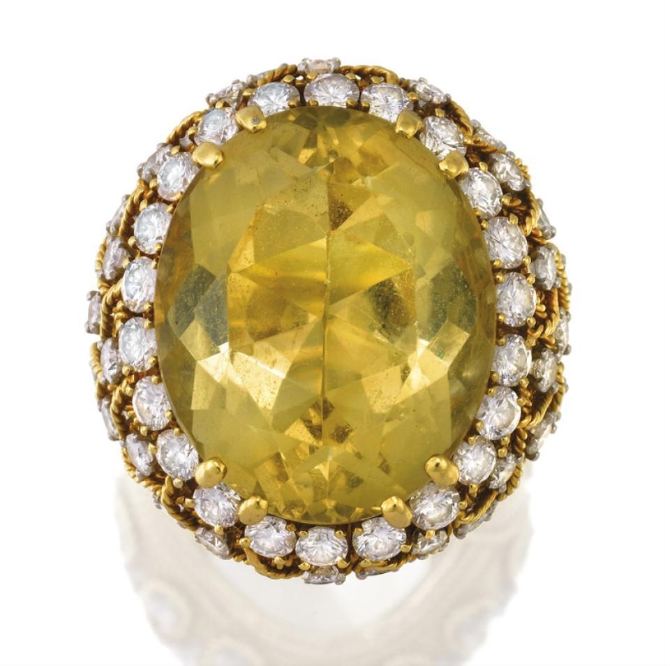 Immerse yourself in the luxurious beauty of the David Webb Bombe Design Ring, a statement piece that elegantly centers around an oval-shaped citrine and is adorned with brilliant-cut diamonds. Crafted in 18K yellow gold and platinum, this ring