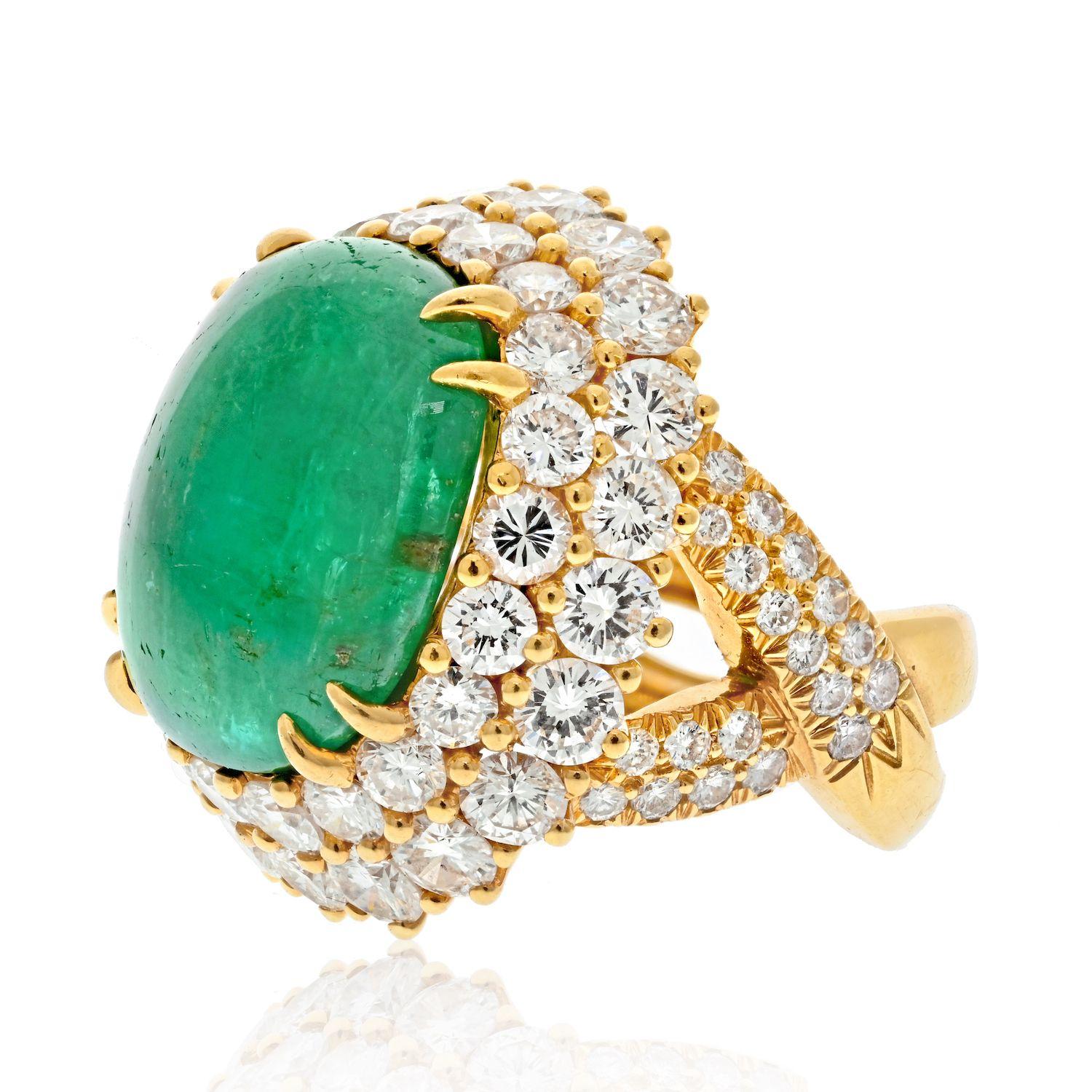 This stunning ring is a classic! Designed by David Webb in the most elegant way. 
Centering upon a rich green cabochon emerald, measuring approx. 26 carats, in a split shank double halo domed diamond set mount. Crafted in 18k Yellow Gold. 
Total